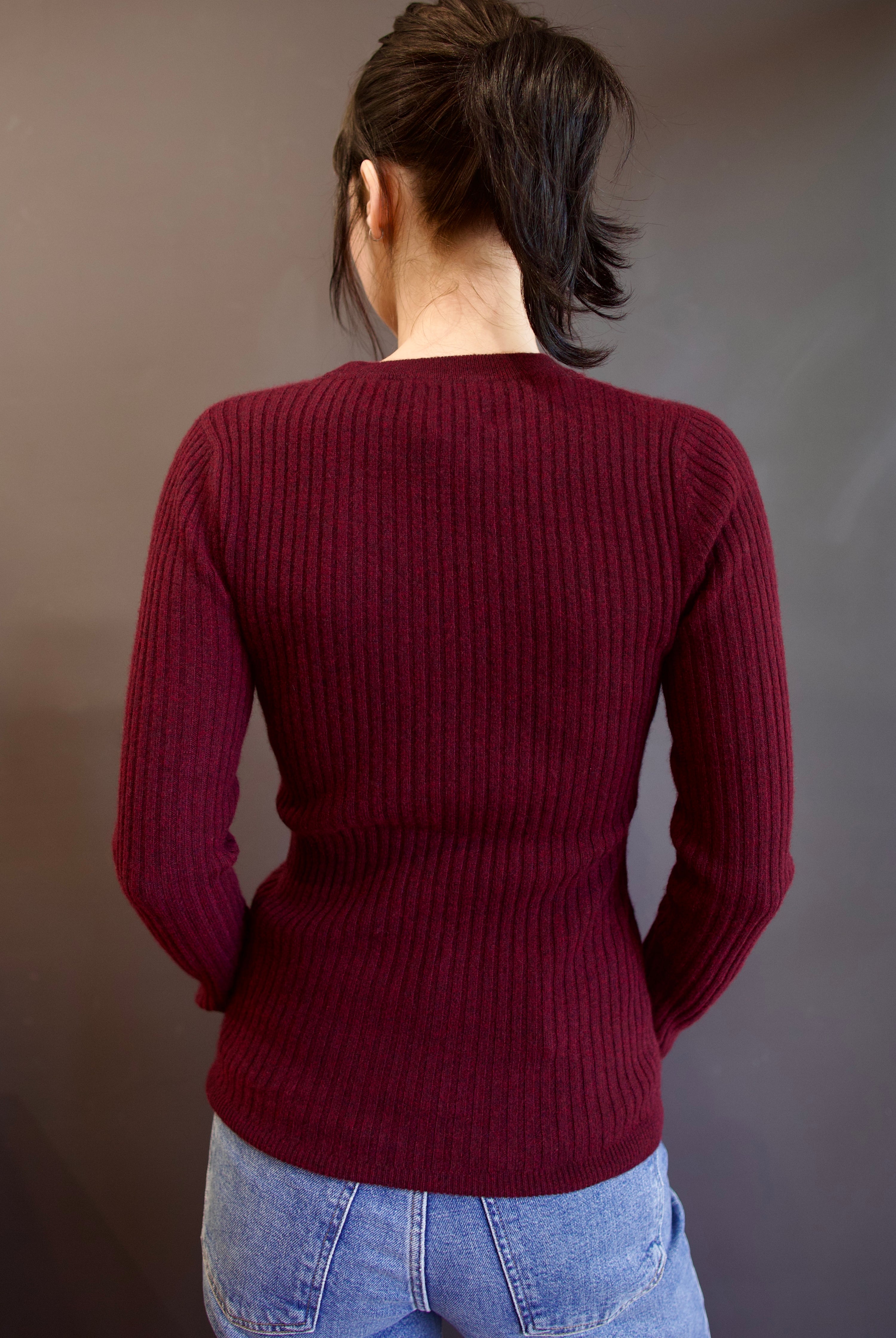 Model wearing luxury french brand Kujten Bibi ribbed cashmere sweater in bordeaux with long sleeves and crew neck.