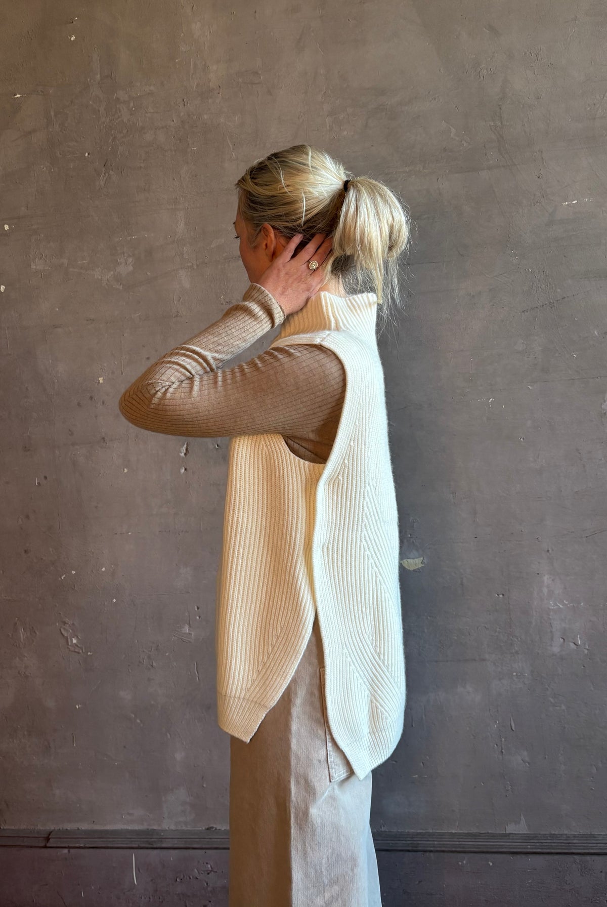 Mature woman wearing Kujten's Erika Funnel Neck Sweater Off White layering piece side snap closure