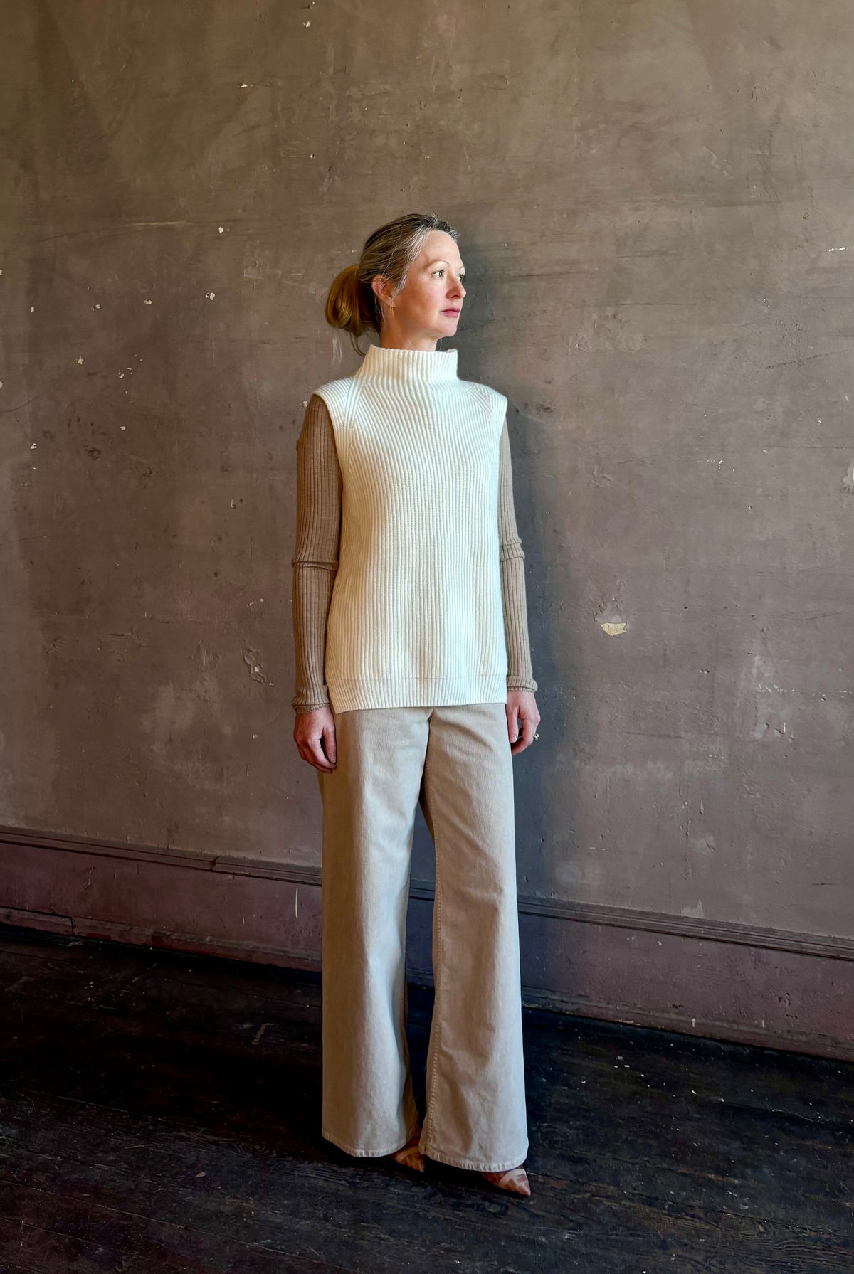 Mature woman wearing Kujten's Erika Funnel Neck Sweater Off White intricate modern design elegant Parisian luxury layering