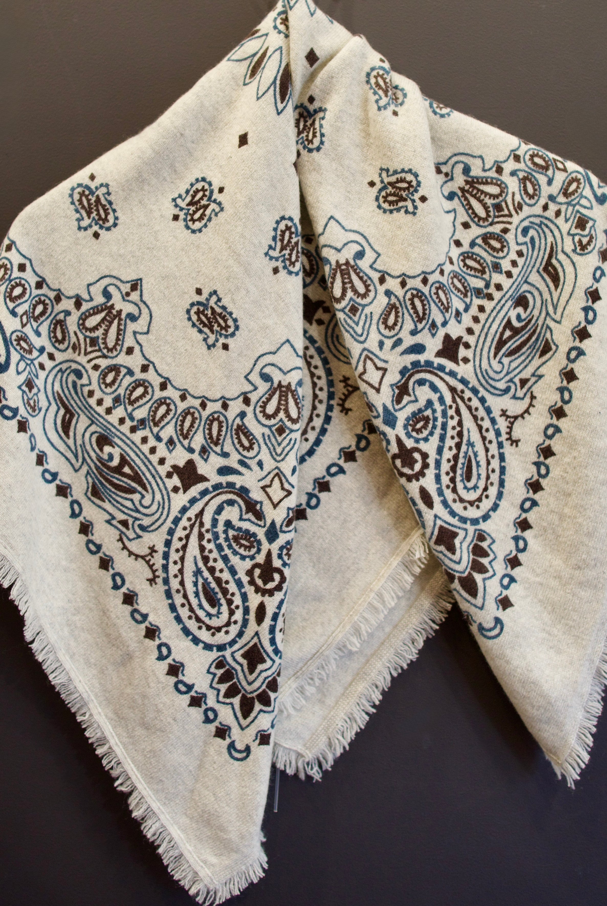 Image of luxury cashmere brand Kujten bandana printed scarf in birch with blue and brown colorway