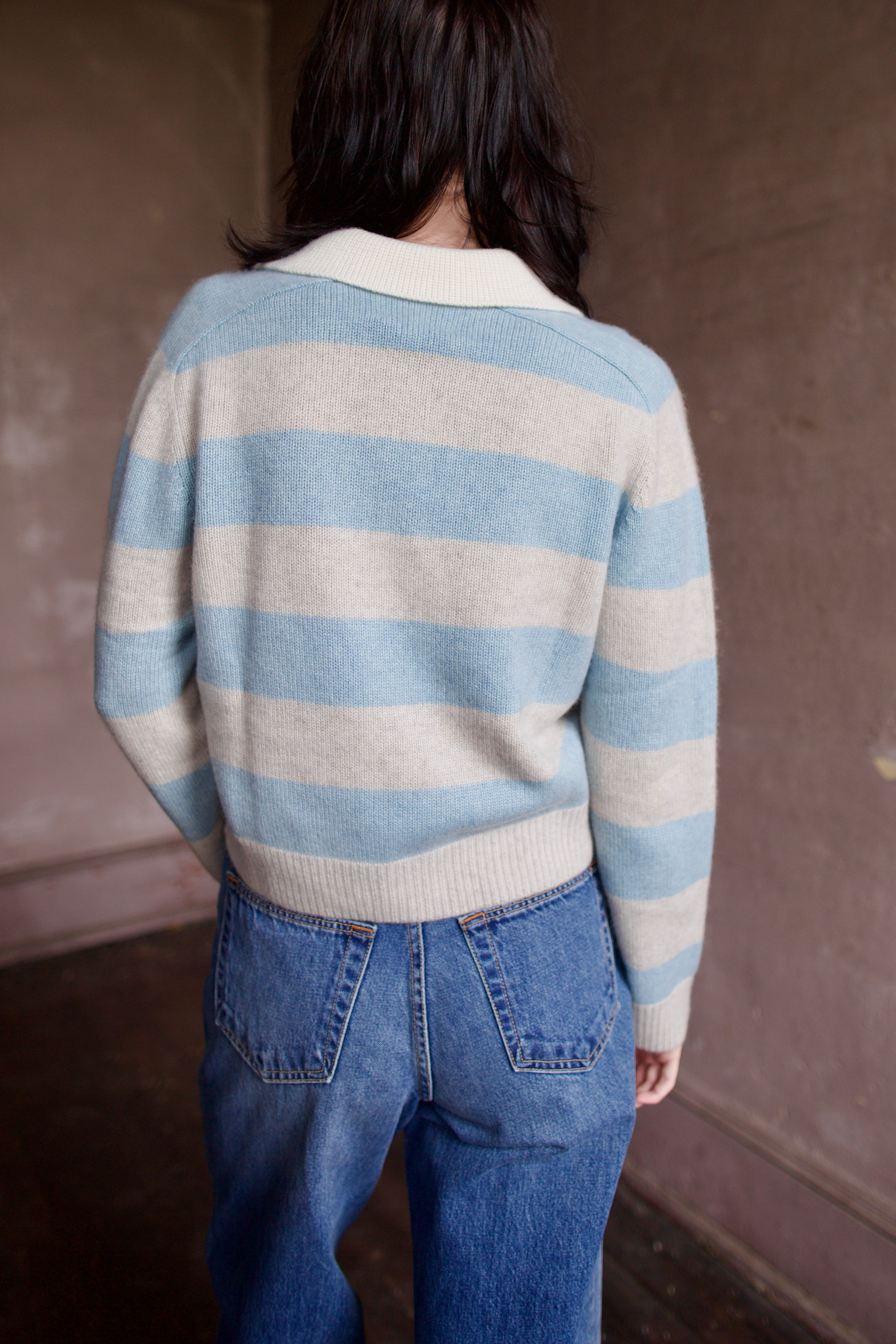 Woman wearing luxury brand Kujten Royce striped long sleeve cashmere polo sweater in light blue and grey
