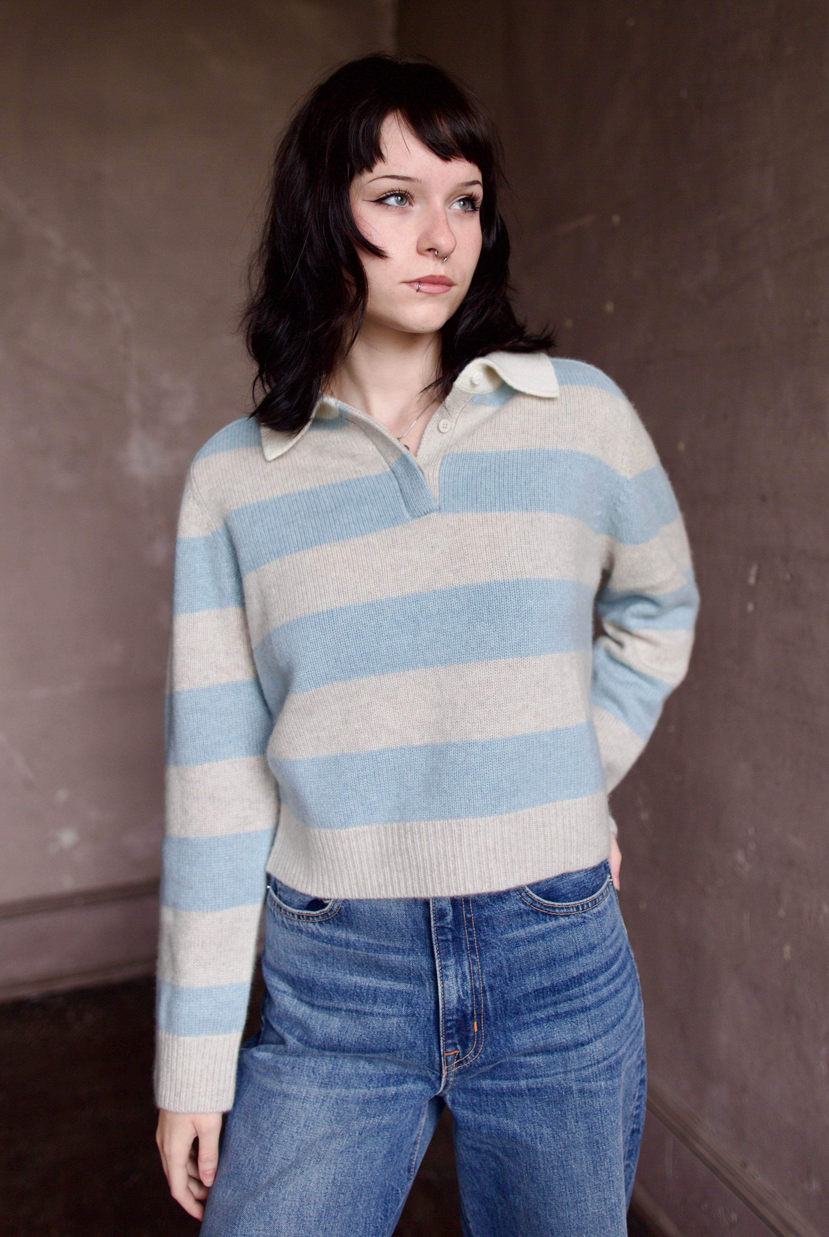 Woman wearing luxury brand Kujten Royce striped long sleeve cashmere polo sweater in light blue and grey