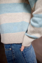 Close-up of luxury brand Kujten Royce striped  cashmere polo sweater in light blue and grey