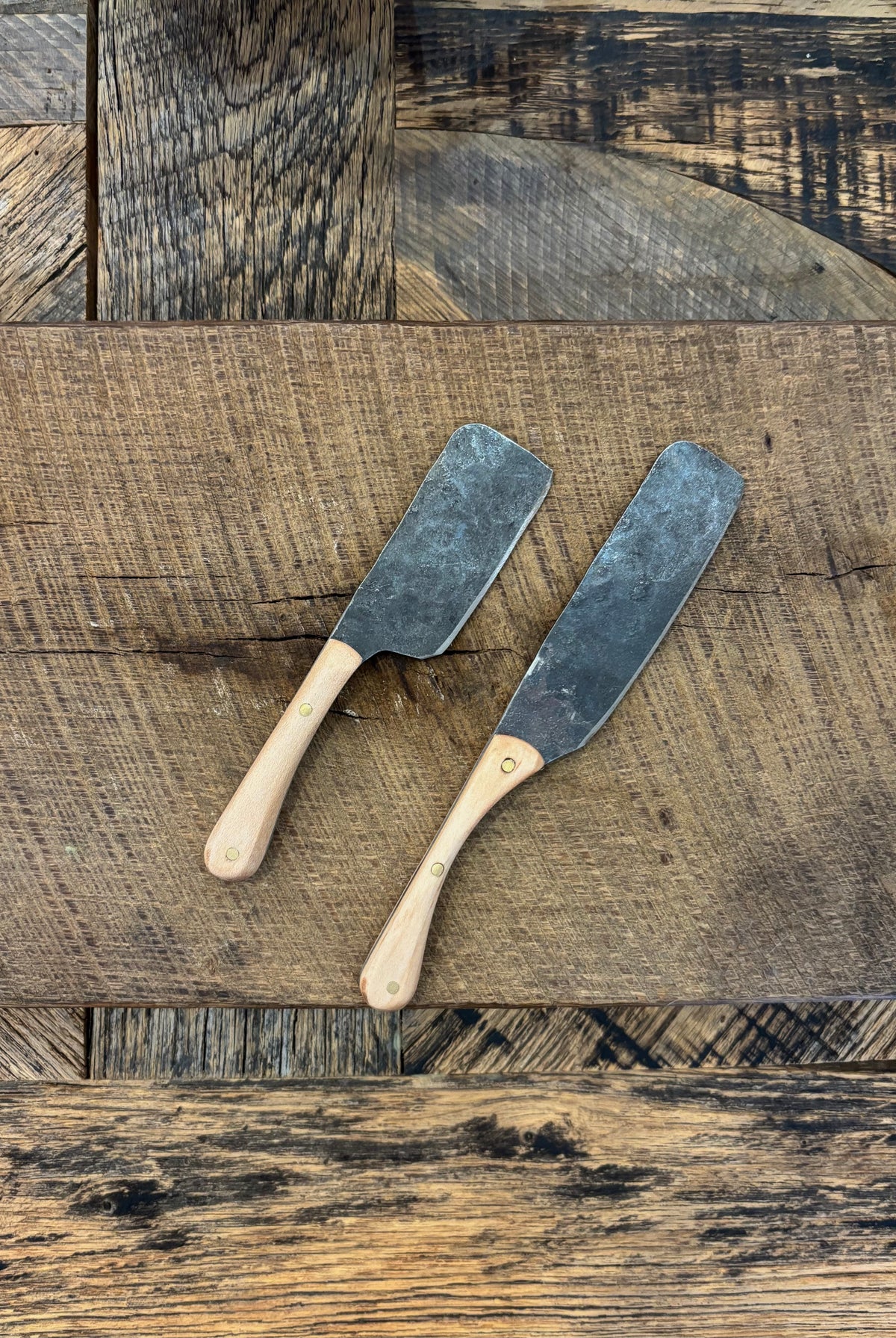 A rustic handcrafted charcuterie serving knife set with a hand forged steel blade and wooden maple handle crafted in USA