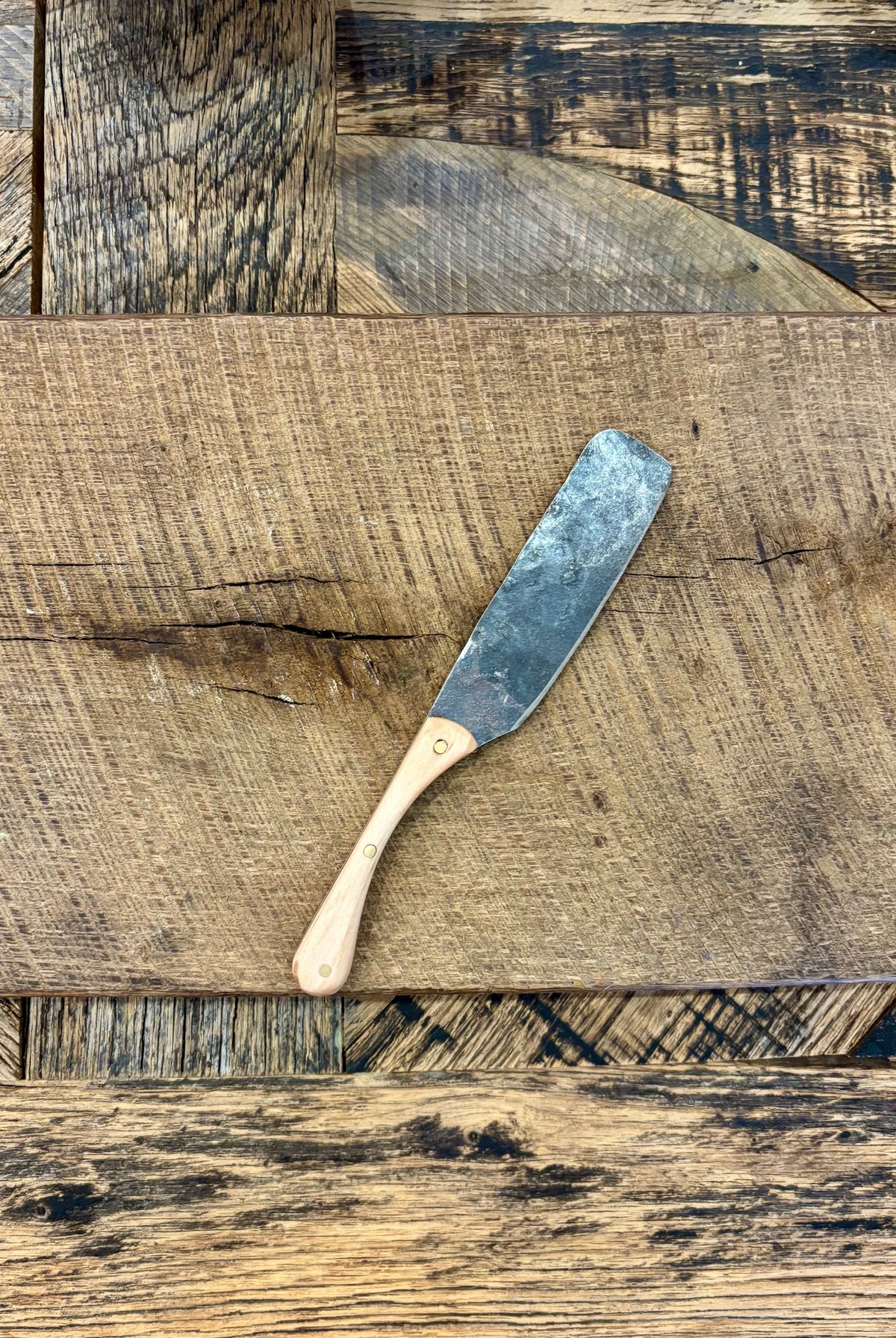 A rustic handcrafted charcuterie serving knife with a hand forged steel blade and wooden maple handle made in USA