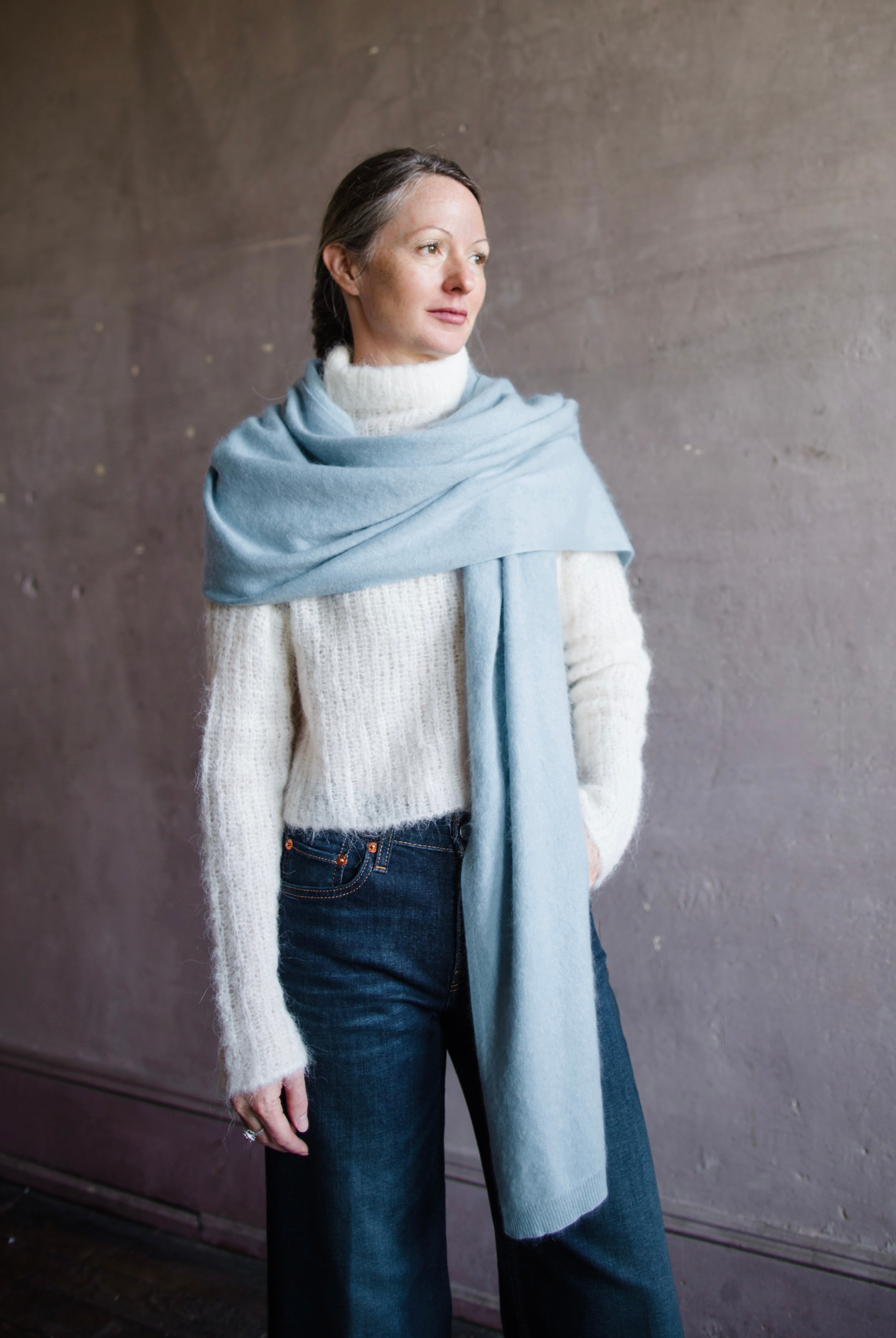 Image featuring a woman wearing the brushed cashmere scarf by Lisa Yang in powder blue.