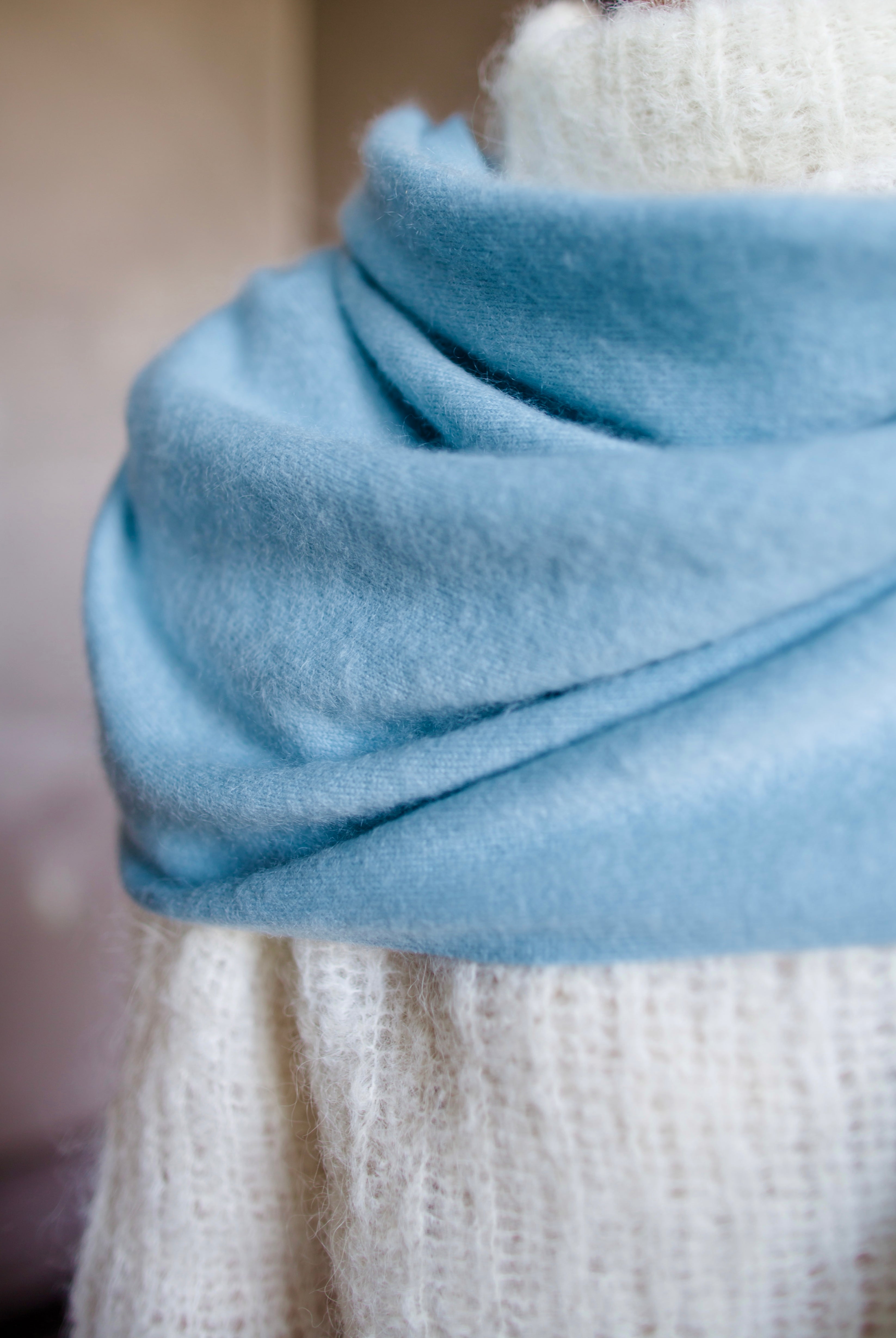 Detail close up image featuring a woman wearing the brushed cashmere scarf by Lisa Yang in powder blue.