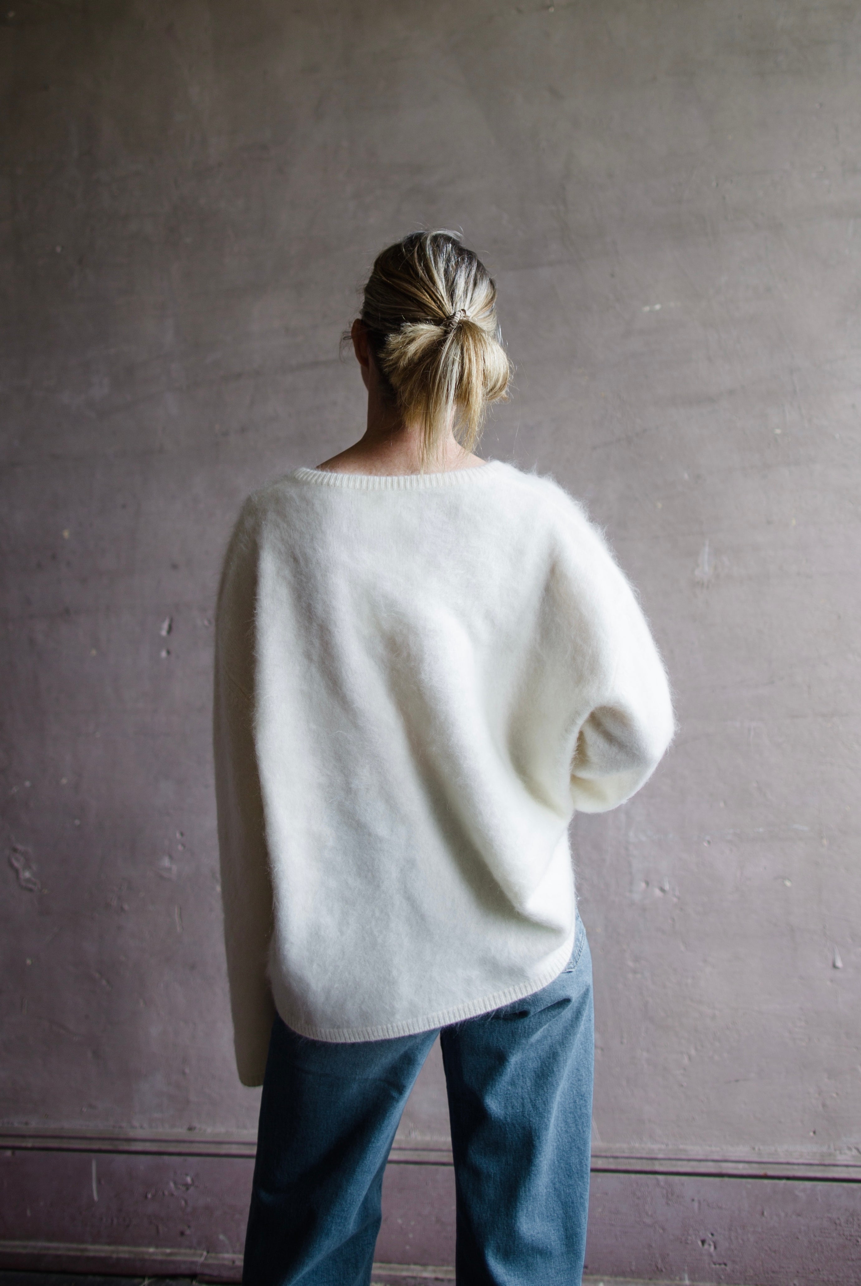 Image featuring a woman wearing the Margareta sweater by Lisa Yang with a deep v neckline, exaggerated sleeves in the softest ivory brushed cashmere.
