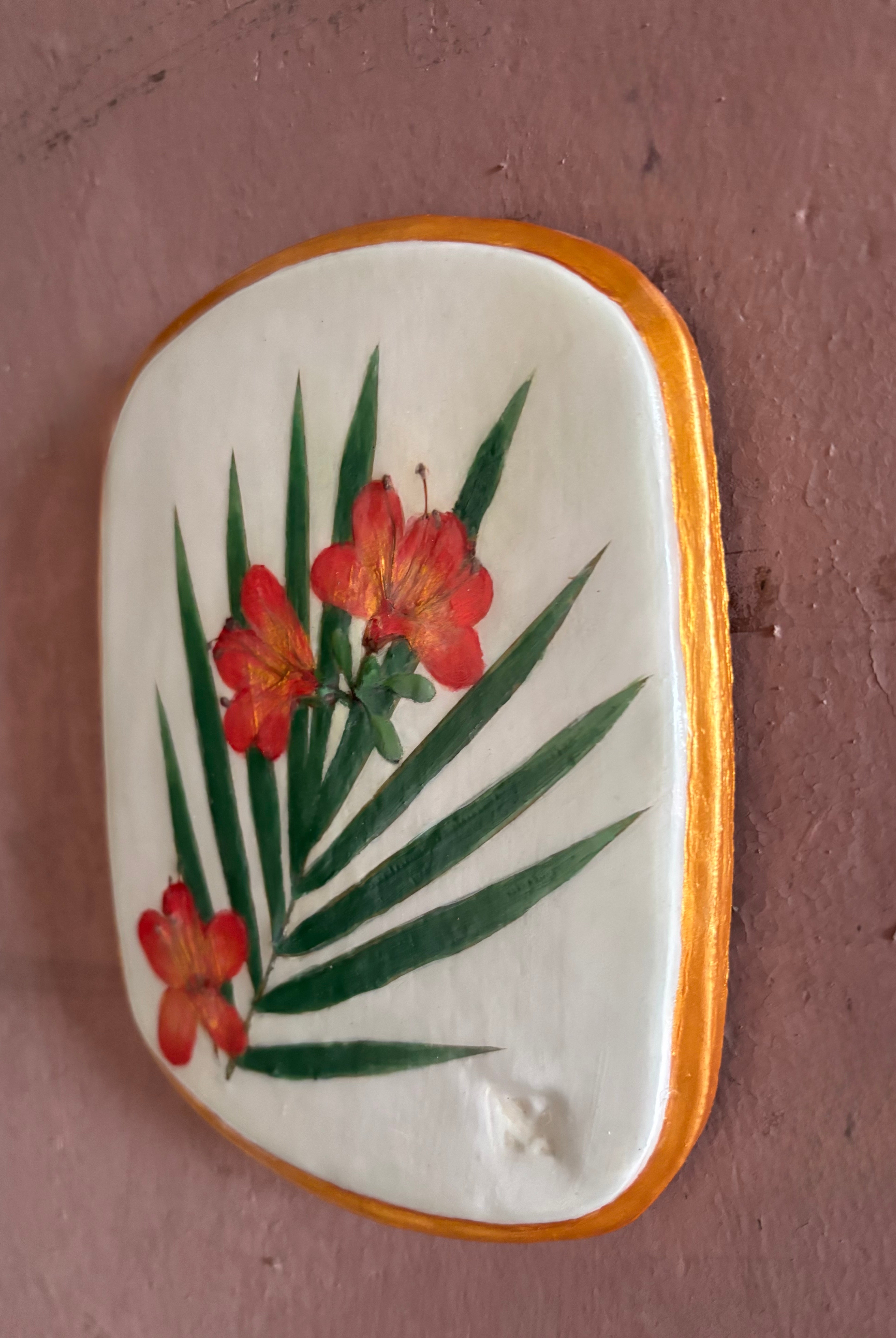 A rectangular ceramic tile featuring botanical pressed azaleas with green palm leaves on white clay