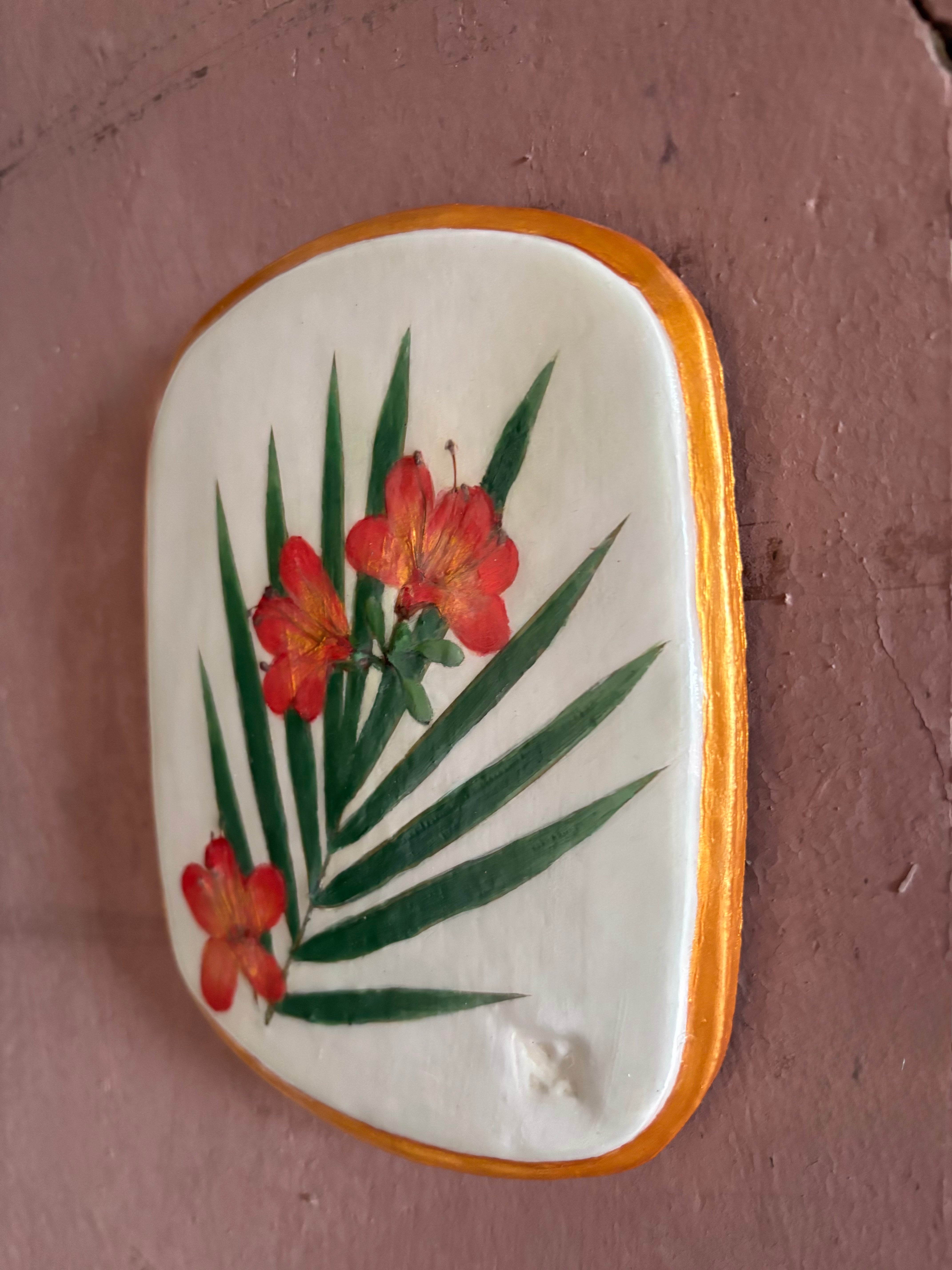 A rectangular ceramic tile featuring botanical pressed azaleas with green palm leaves on white clay