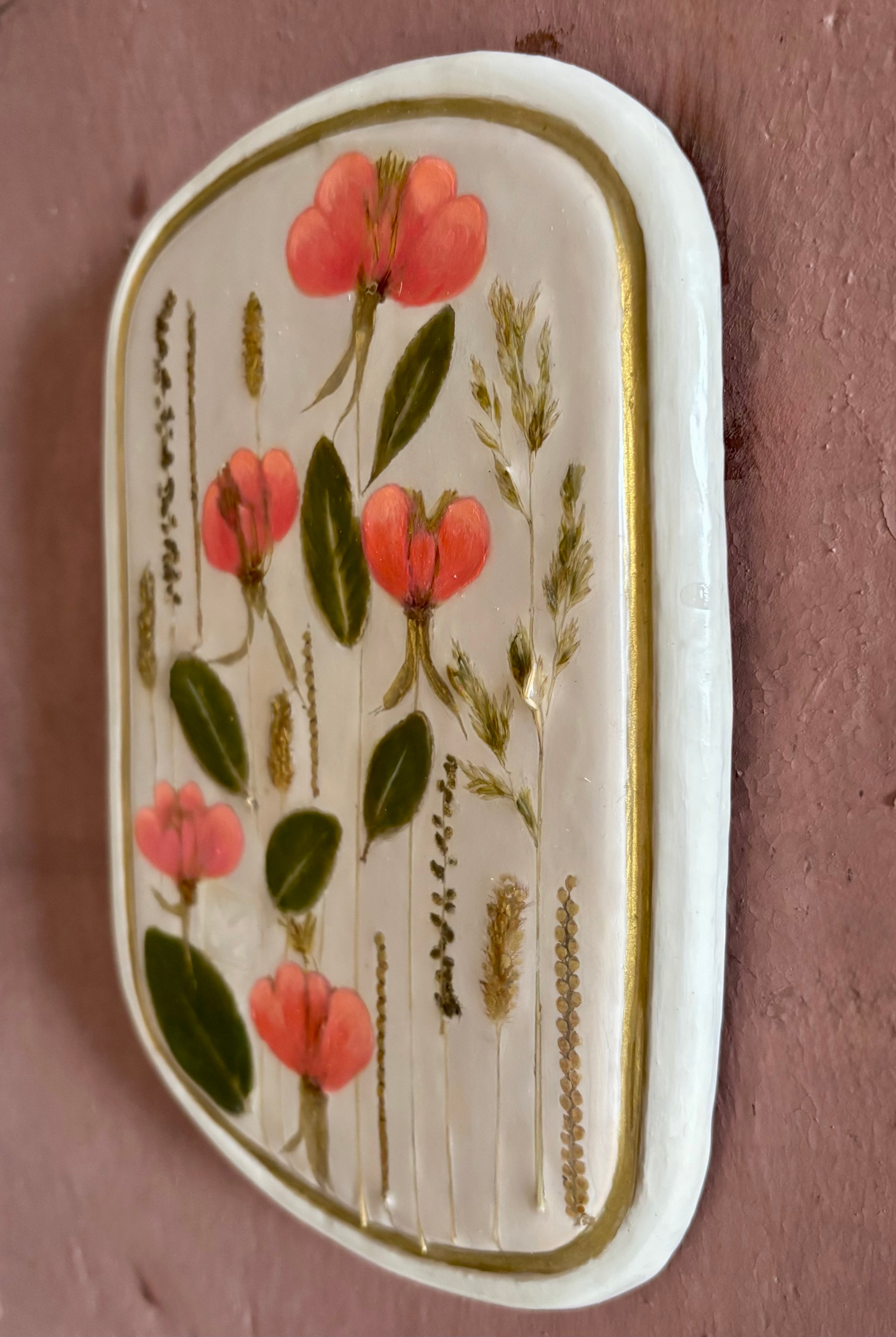 A rectangular ceramic tile with botanical pressed evening primrose flowers grasses and boxwoods on cream clay