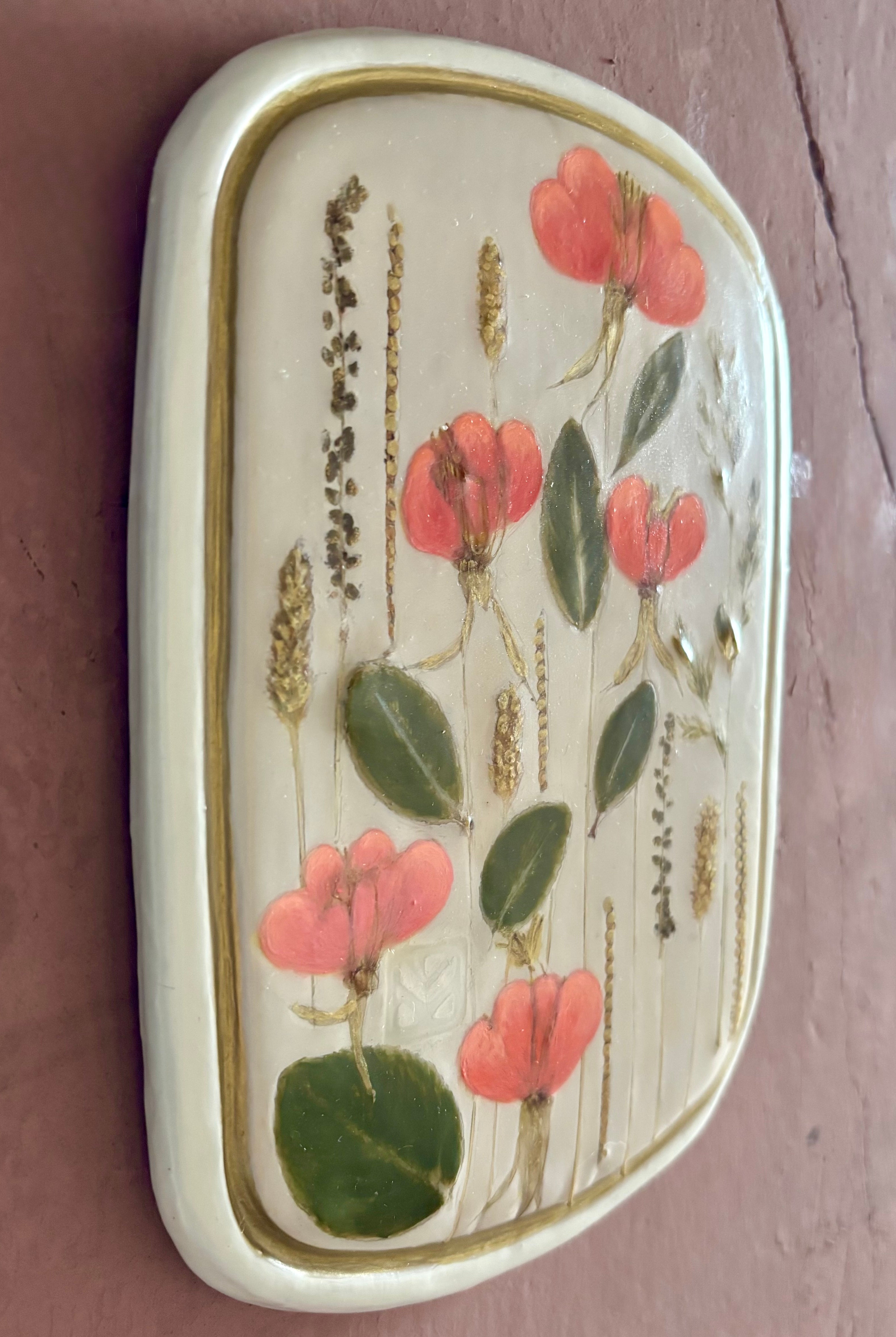 A rectangular ceramic tile with botanical pressed evening primrose flowers grasses and boxwoods on cream clay