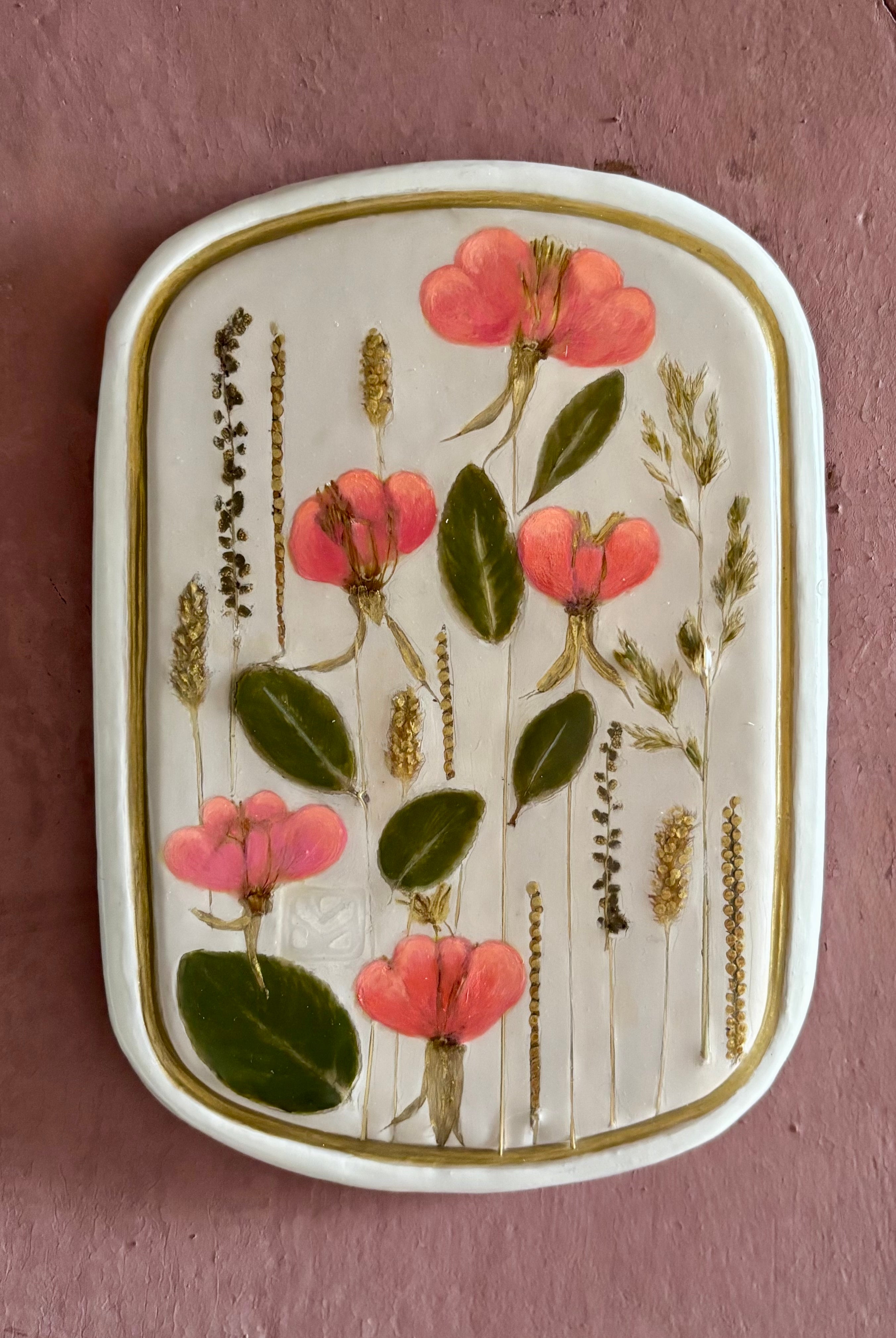 A rectangular ceramic tile with botanical pressed evening primrose flowers grasses and boxwoods on cream clay