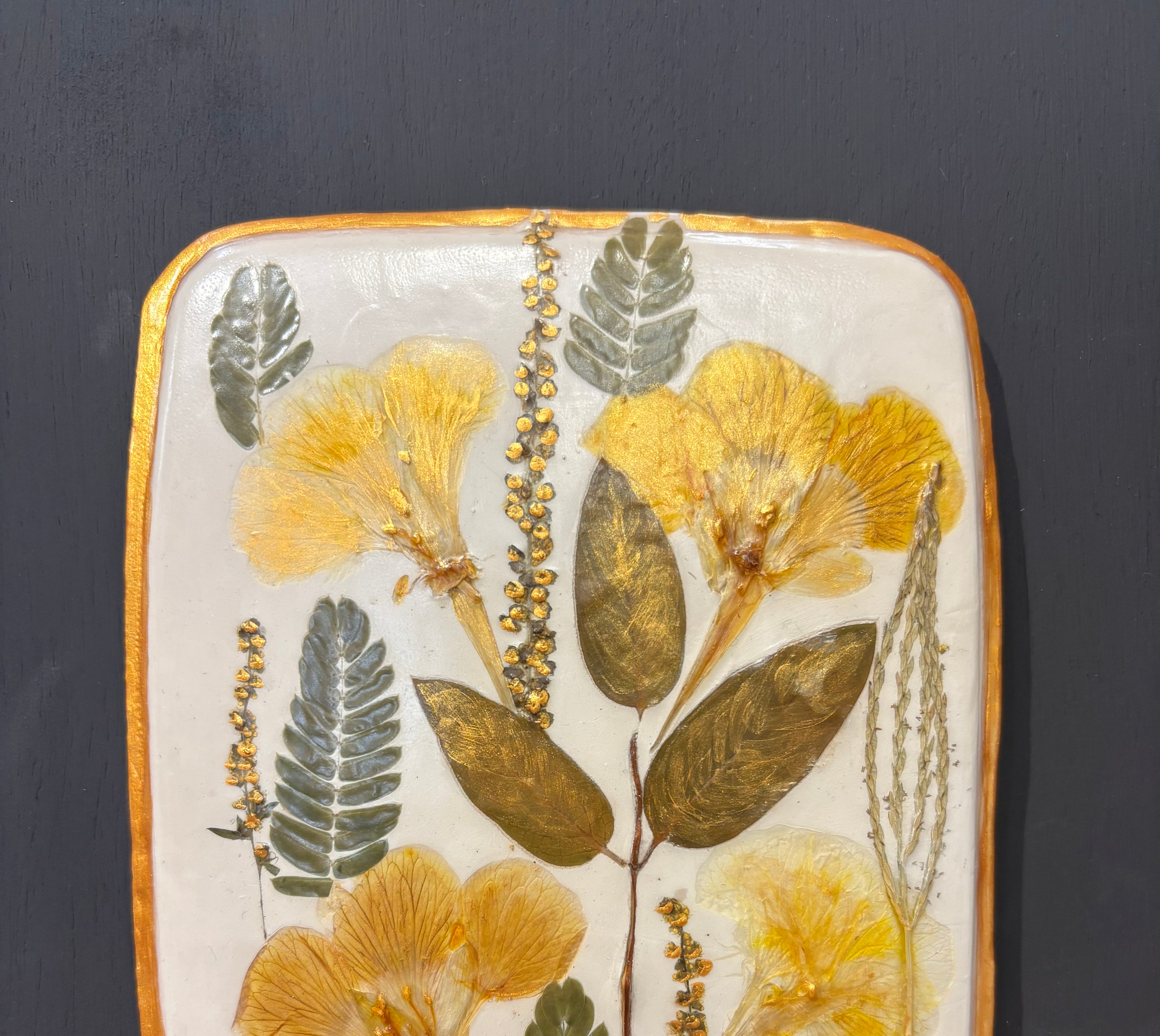 A square ceramic tile with botanical pressed wild evening yellow primrose and foliage on cream clay by NC artist