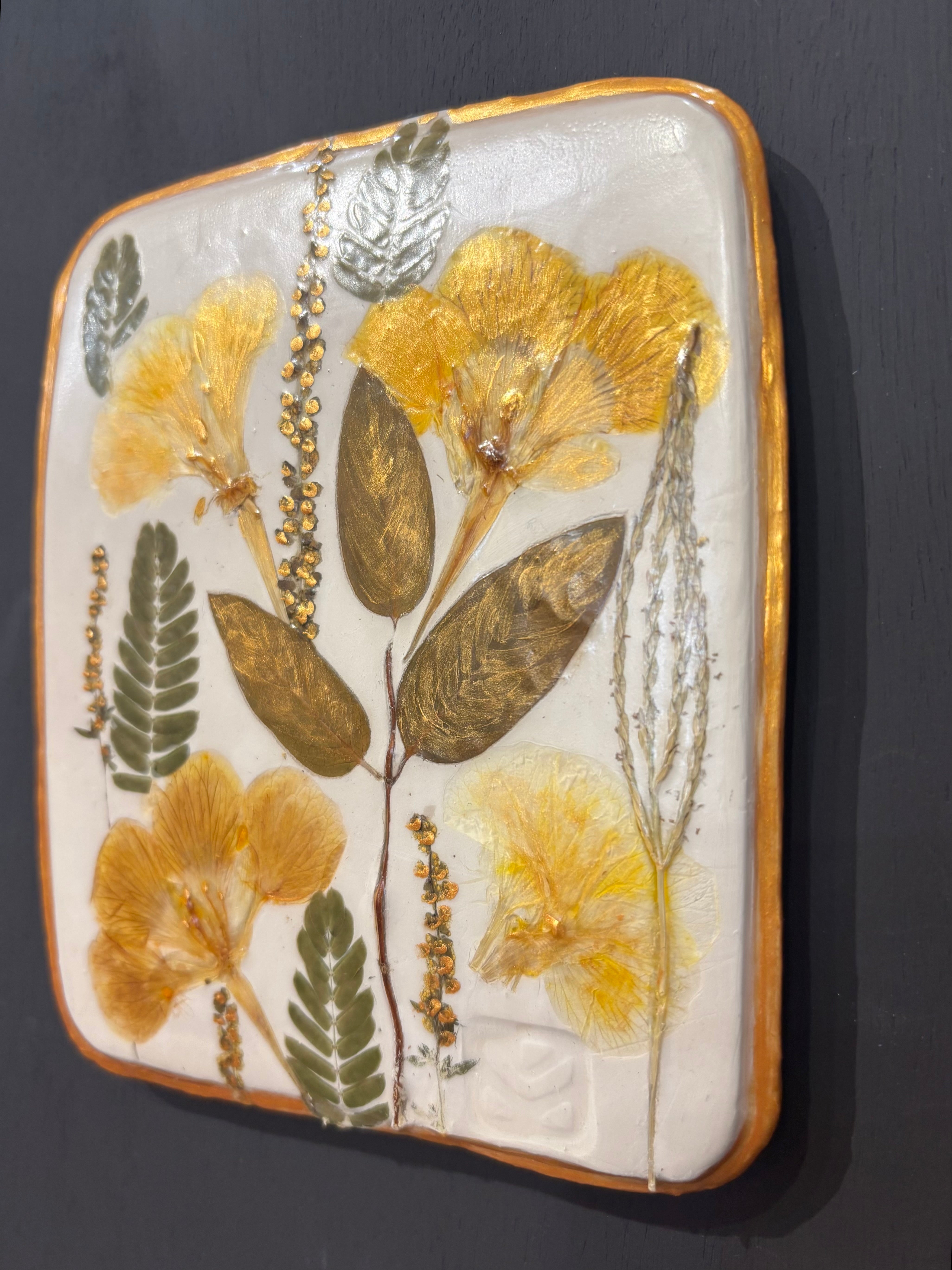 A square ceramic tile with botanical pressed wild evening yellow primrose and foliage on cream clay by NC artist