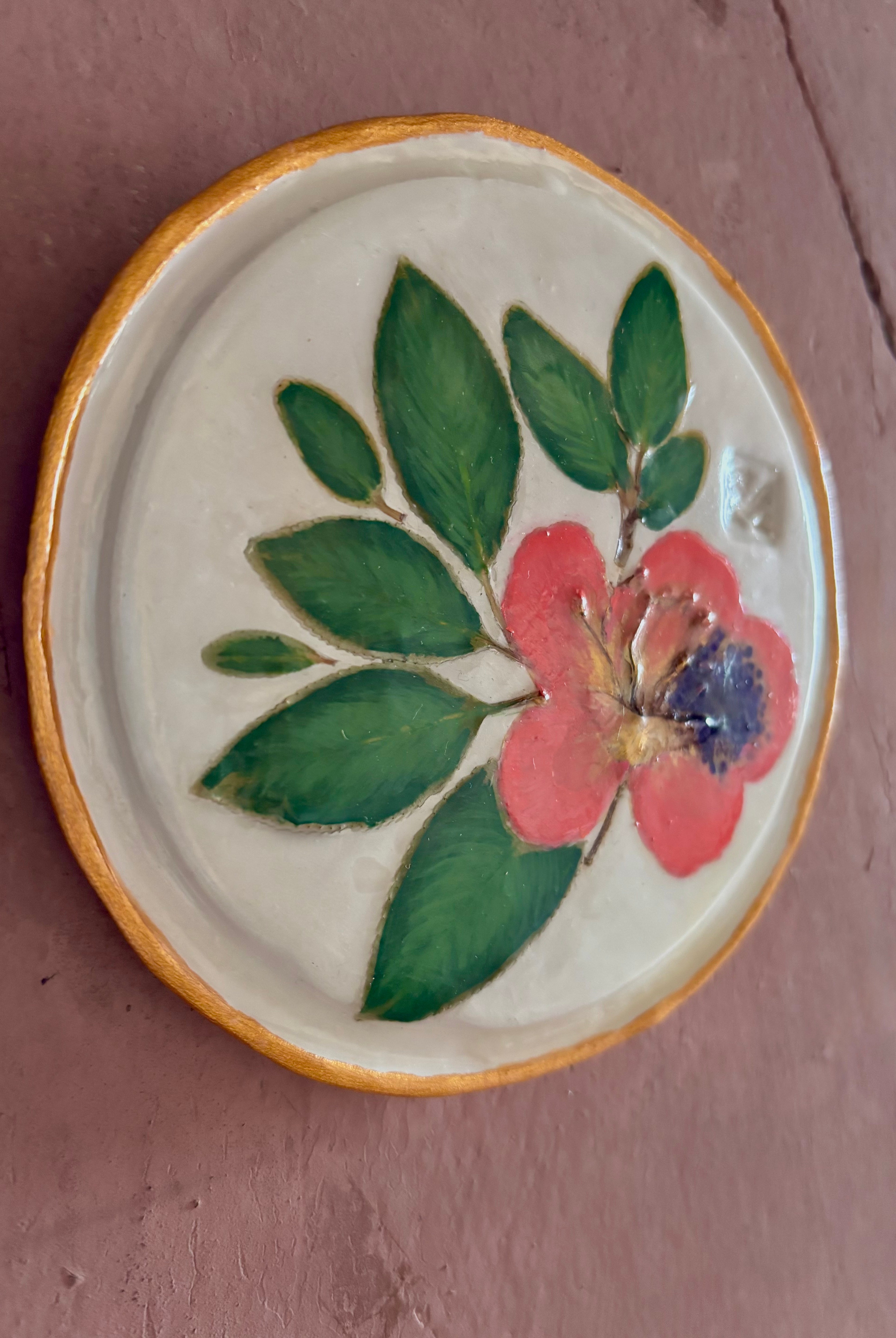A round white ceramic tile with sappora rhododendron bloom botanical press green leaves and hand painted gold rim