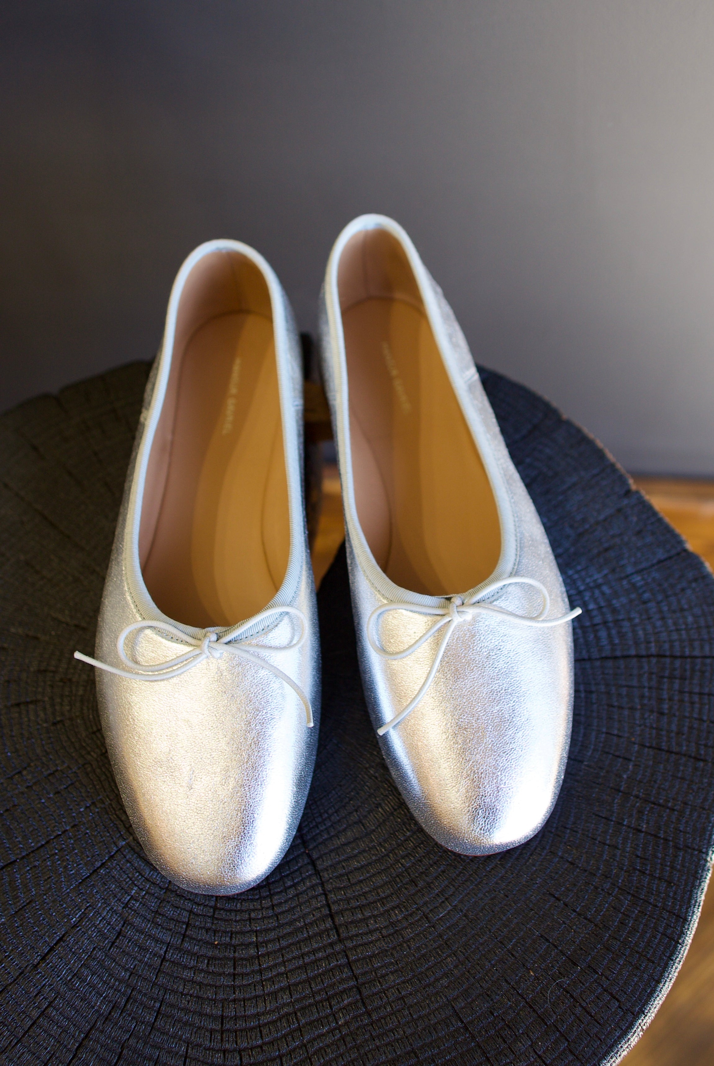 Image featuring the Dream Ballerina Flats by Mansur Gavriel with a small bow with a round toe and flat heel in matte silver.