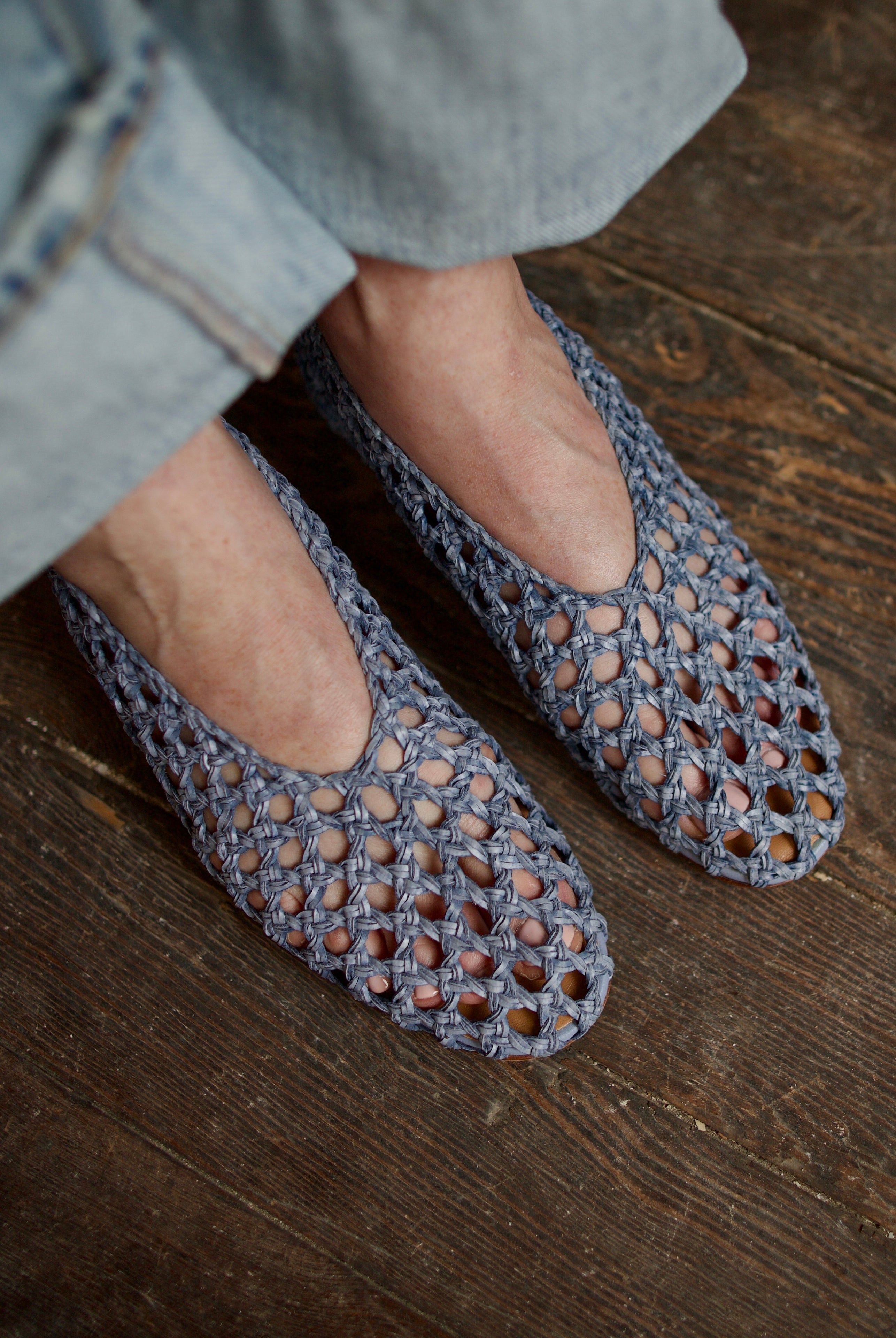 Model showcasing intricately woven luxury footwear casual blue ballerina flats by Mansur Gavriel