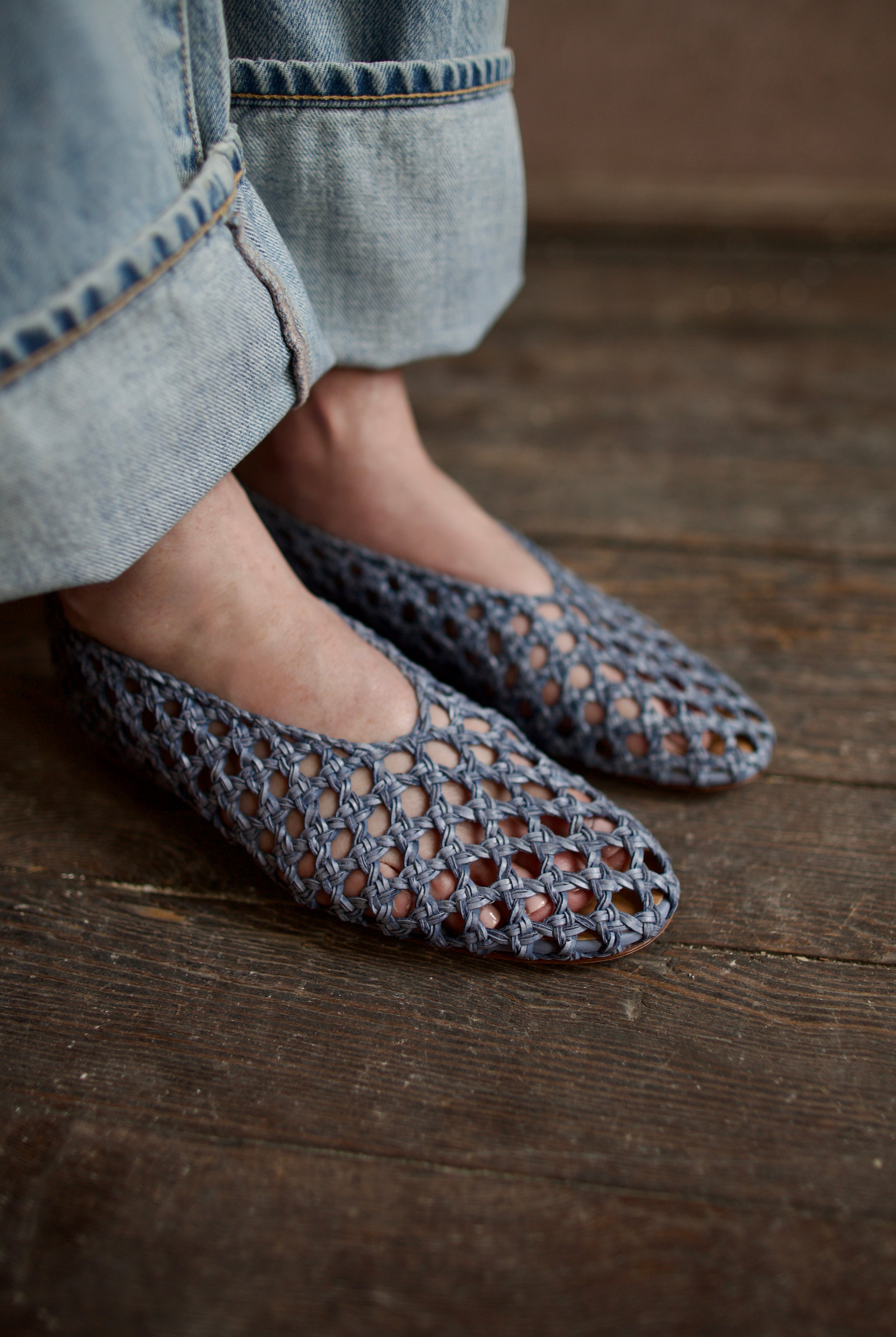 Model showcasing intricately woven women's luxury footwear casual blue ballerina flats by Mansur Gavriel