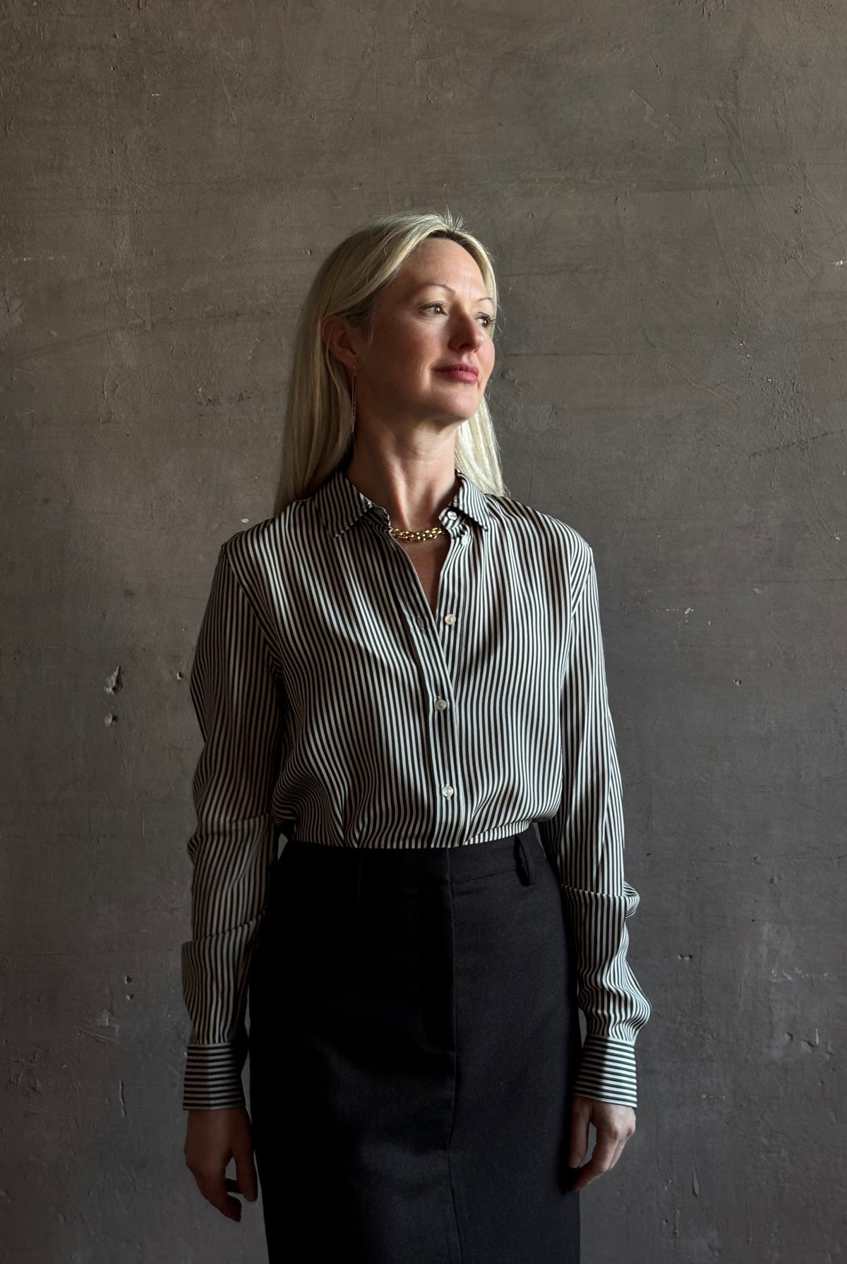 Mature woman wearing Nili Lotan Gaia Slim Silk Shirt in Dark Brown/Cream Stripe classic collar, cuffed sleeves Made in the USA