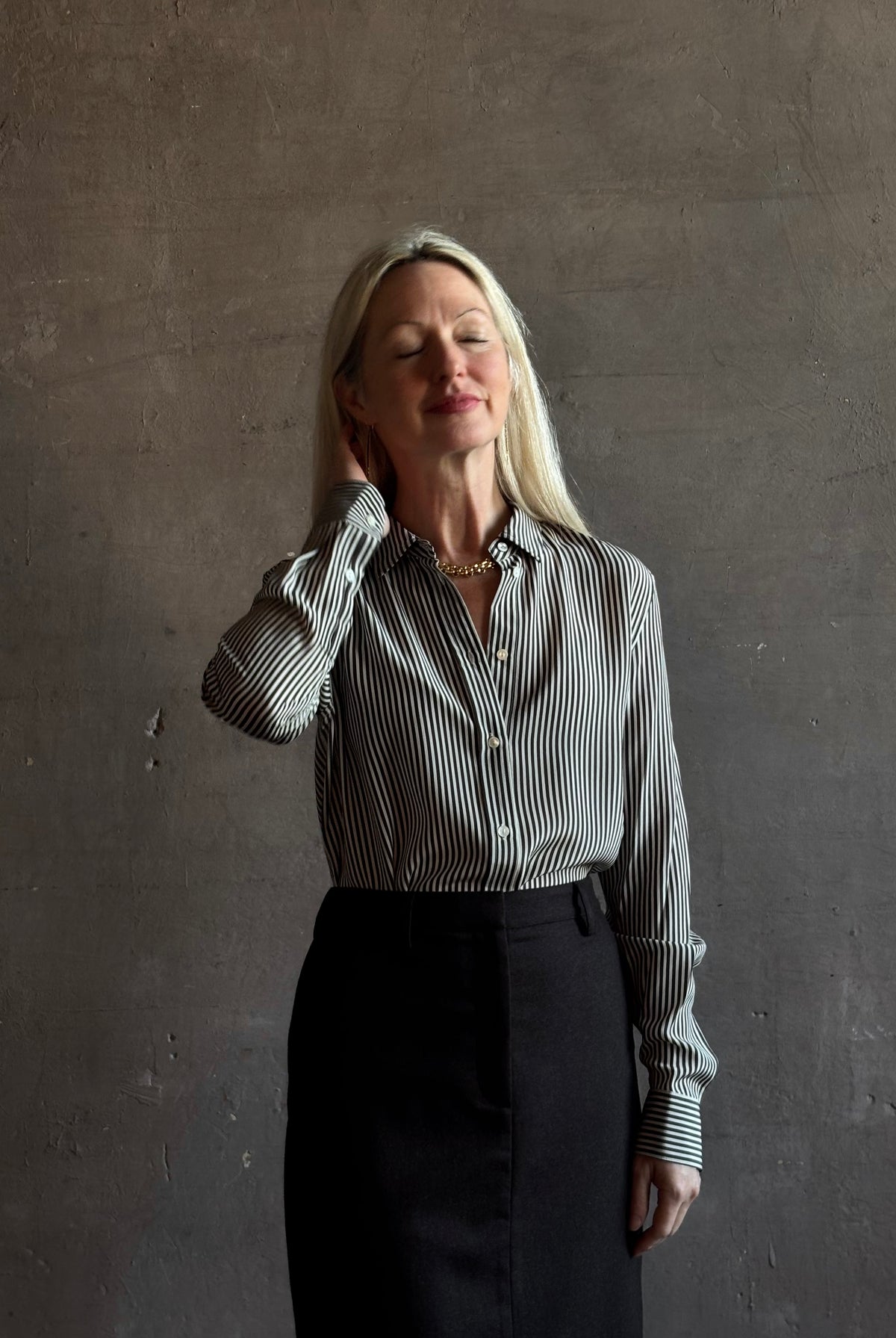 Mature woman wearing Nili Lotan Gaia Slim Silk Shirt in Dark Brown/Cream Stripe classic collar, cuffed sleeves Made in the USA