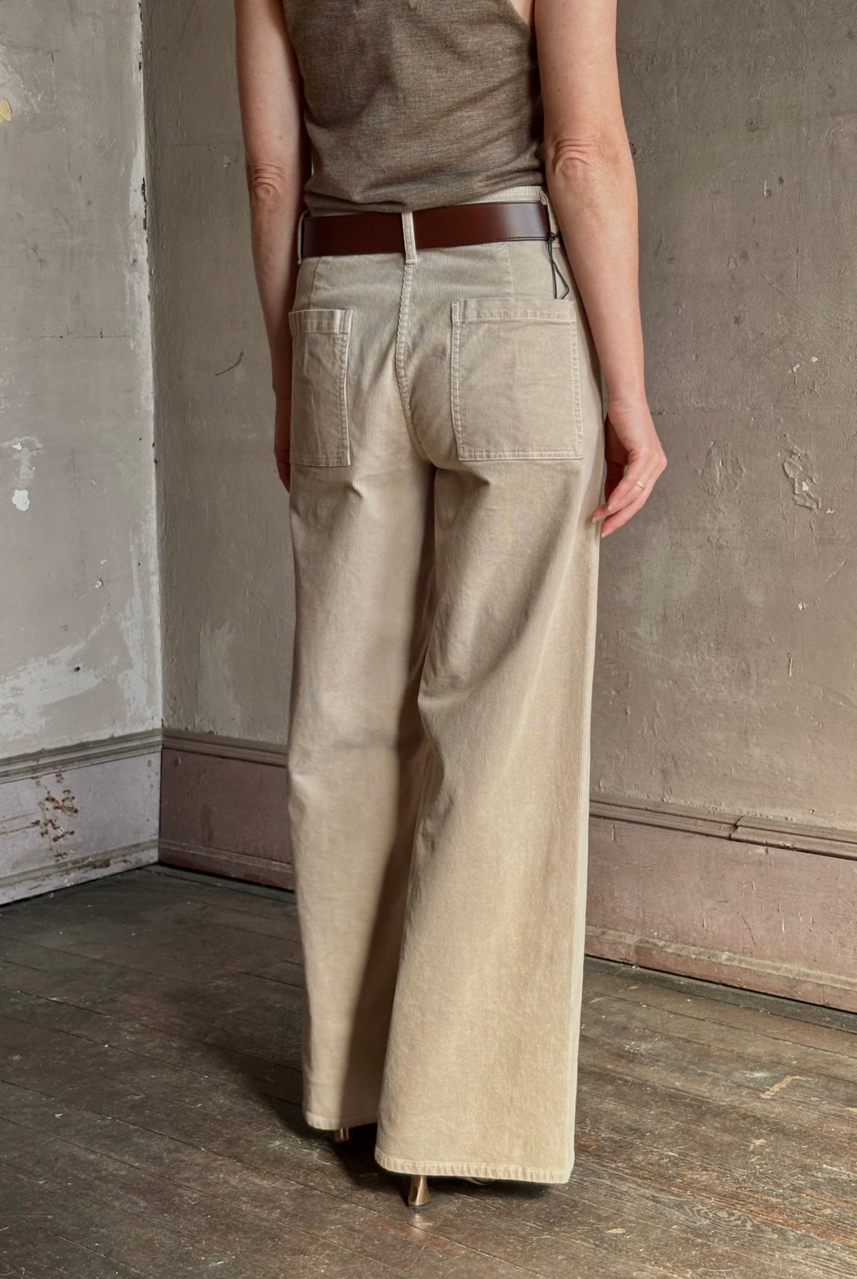 Mature woman wearing Nili Lotan flat front straight leg megan pant in beige corduroy mid rise machine washable cotton