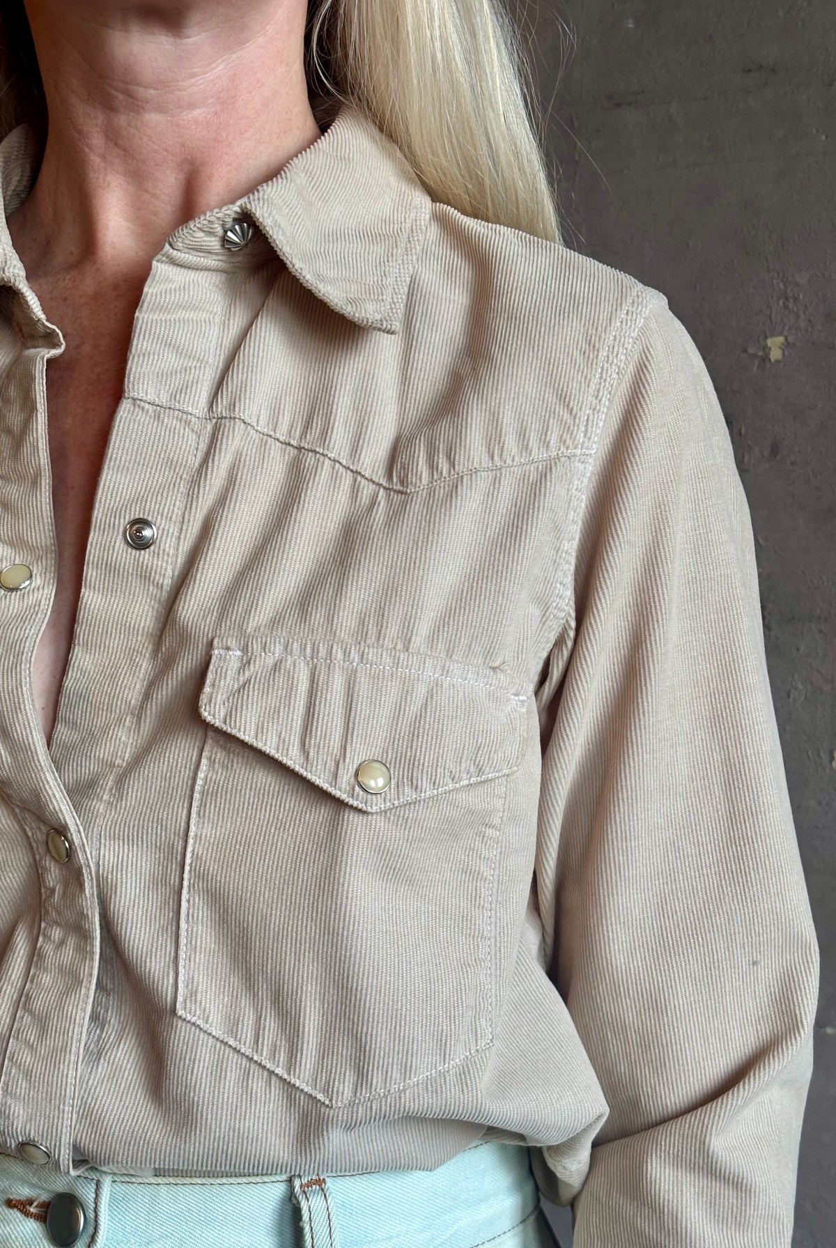 Mature woman wearing Nili Lotan's Travis Corduroy Shirt in Travertine cotton corduroy Western-inspired snap buttons