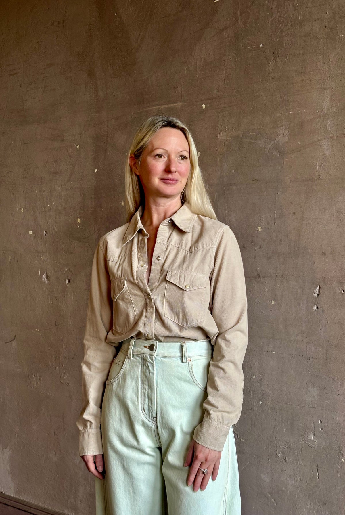 Mature woman wearing Nili Lotan's Travis Corduroy Shirt in Travertine cotton corduroy Western-inspired snap buttons