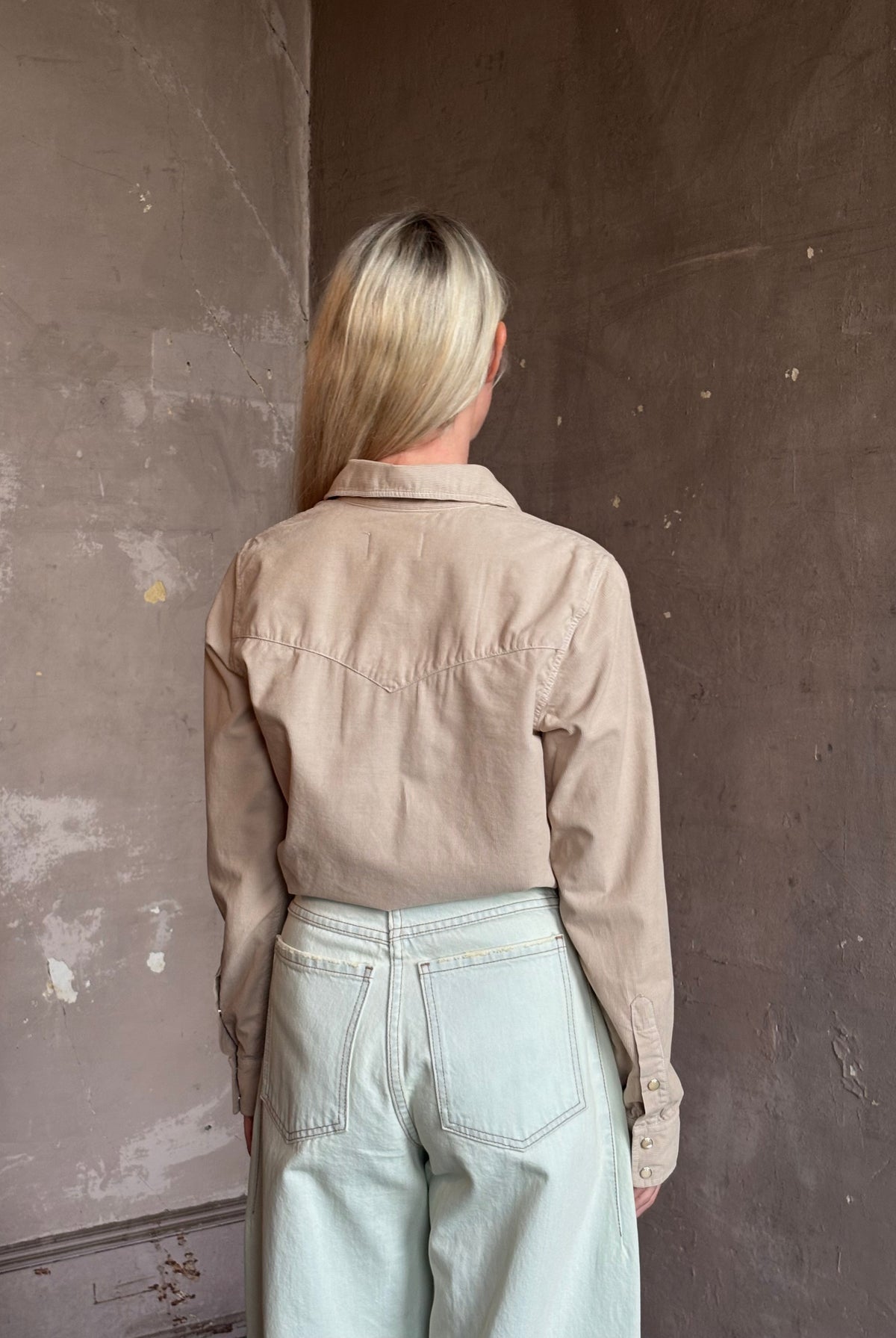 Mature woman wearing Nili Lotan's Travis Corduroy Shirt in Travertine cotton corduroy Western-inspired snap buttons