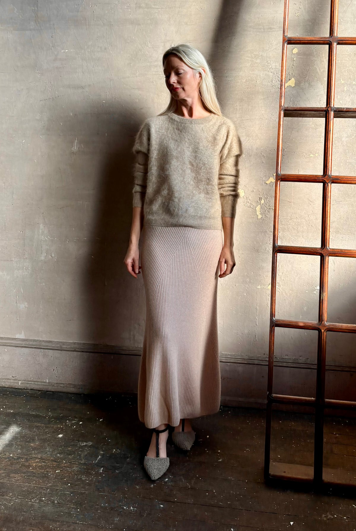 Mature woman wearing Naadam's Ribbed Maxi Skirt in Blush wool-cashmere blend flexible waistband modern ribbed silhouette Soft elongating ethical luxury