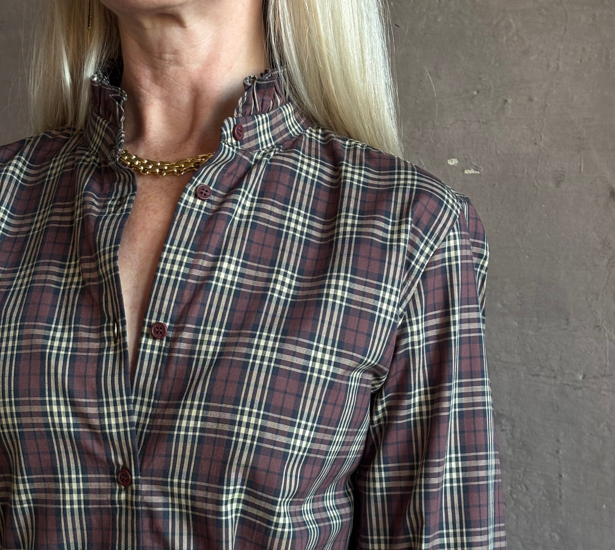 close up of Mature woman wearing Nili Lotan Elio Cotton Shirt in Rustic Check with a small ruffle lined mandarin collar in burgundy navy and khaki plaid print