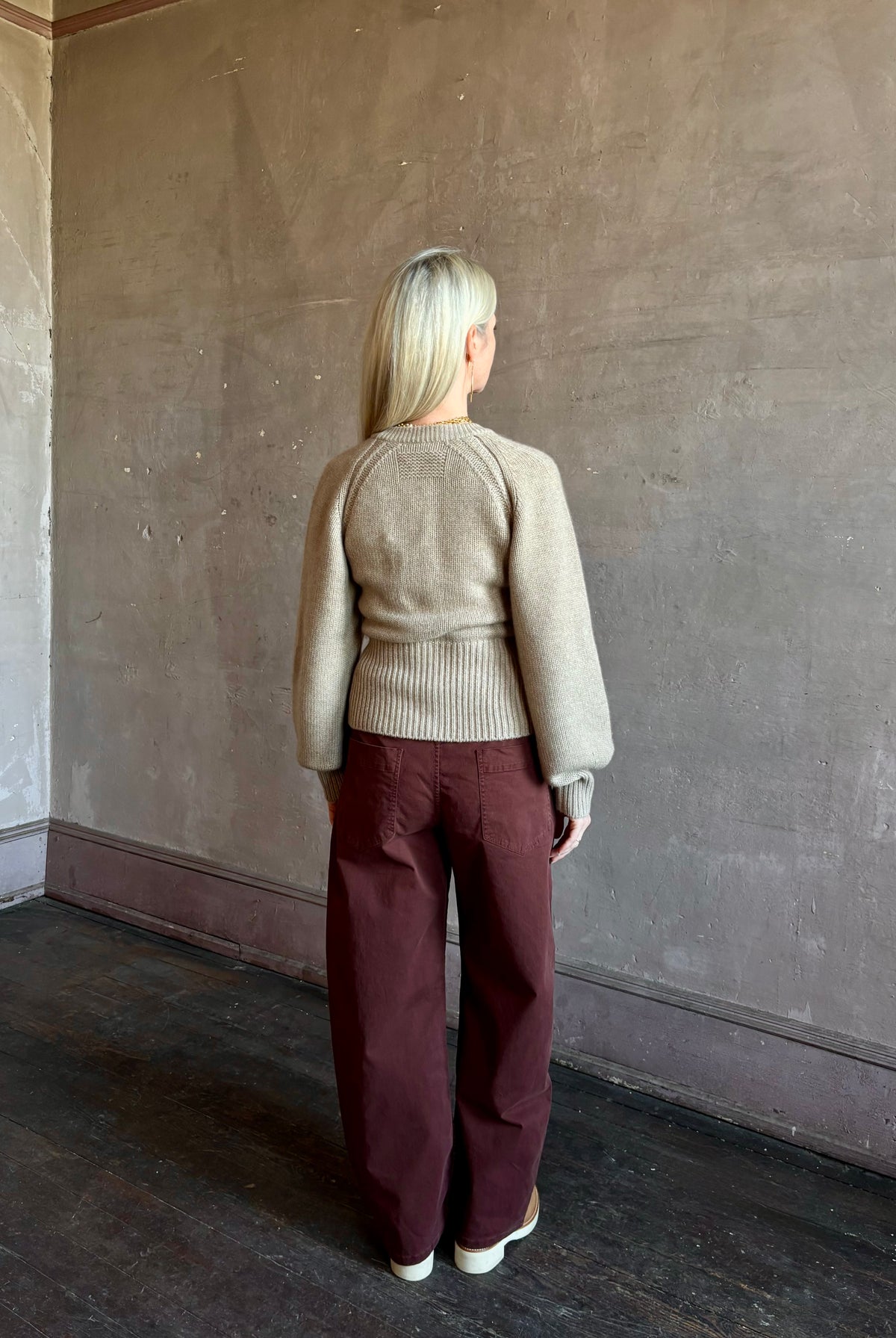 Mature woman wearing Nili Lotan’s Tribeca Pant in Cabernet a cotton-elastane barrel leg with a relaxed fit mid-rise jewel-toned, effortlessly easy