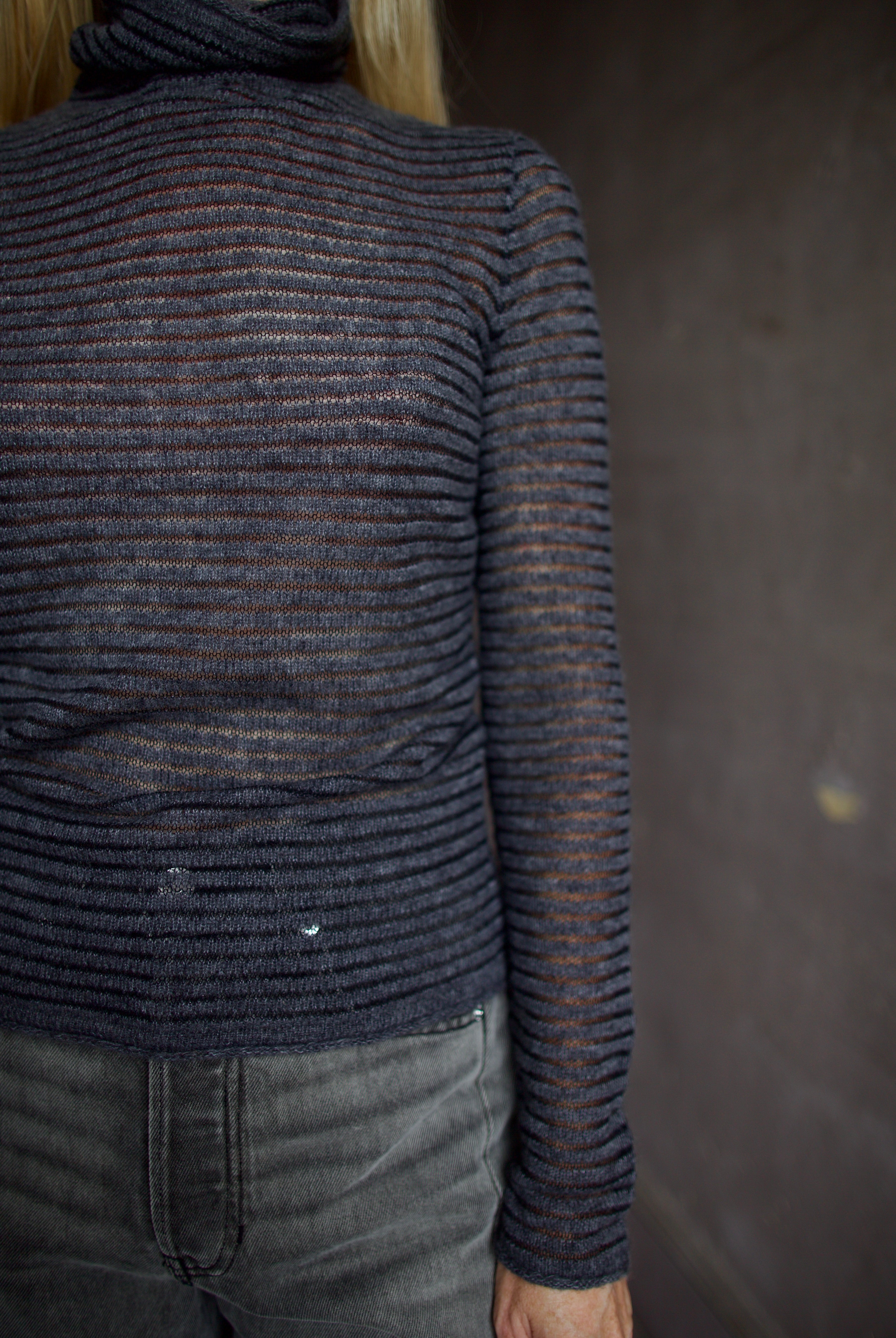 Model wearing a dark ribbed Proenza Schouler striped mock neck sweater and gray Veronica Beard barrel denim