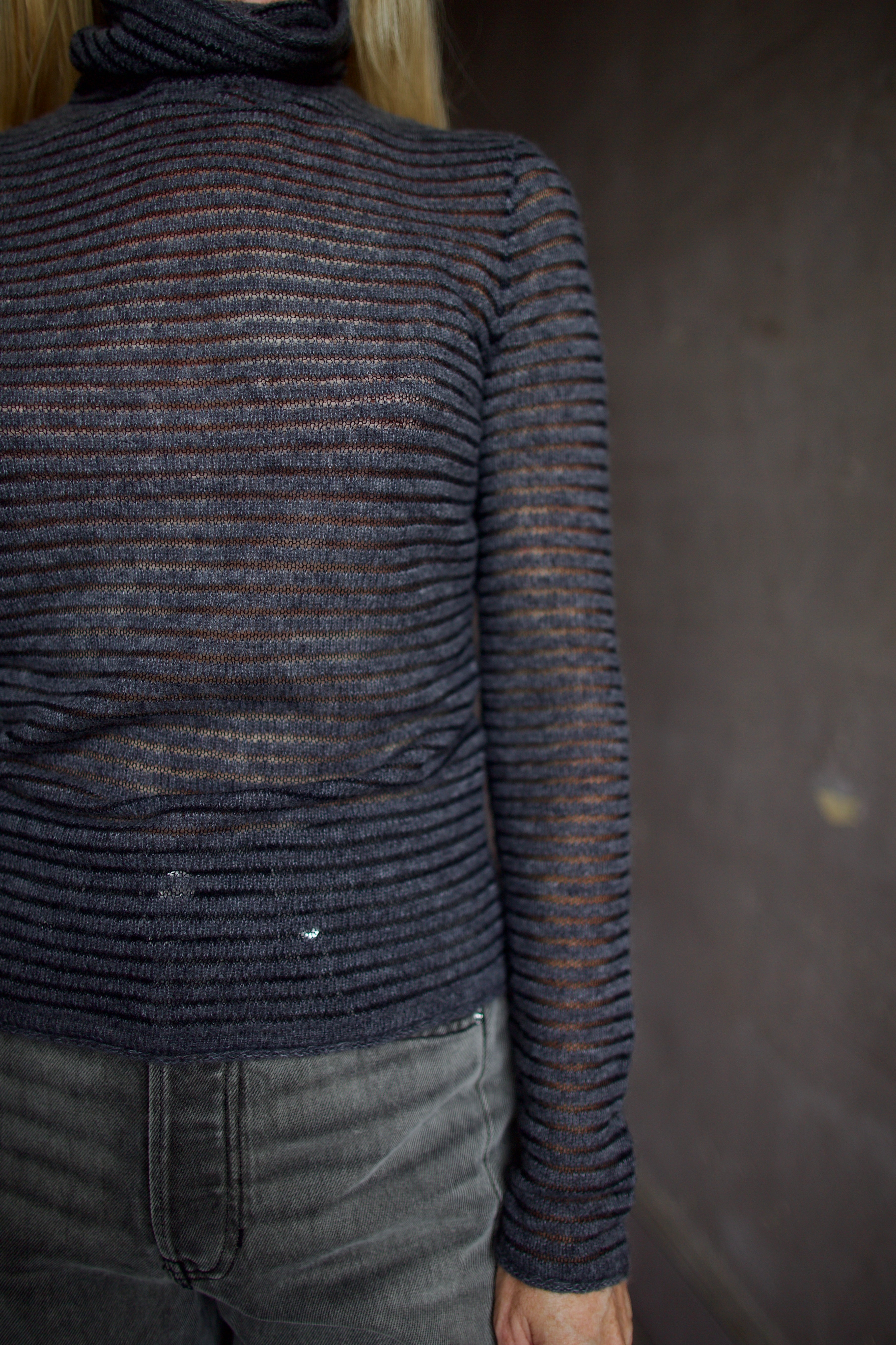 Model wearing a dark ribbed Proenza Schouler striped mock neck sweater and gray Veronica Beard barrel denim