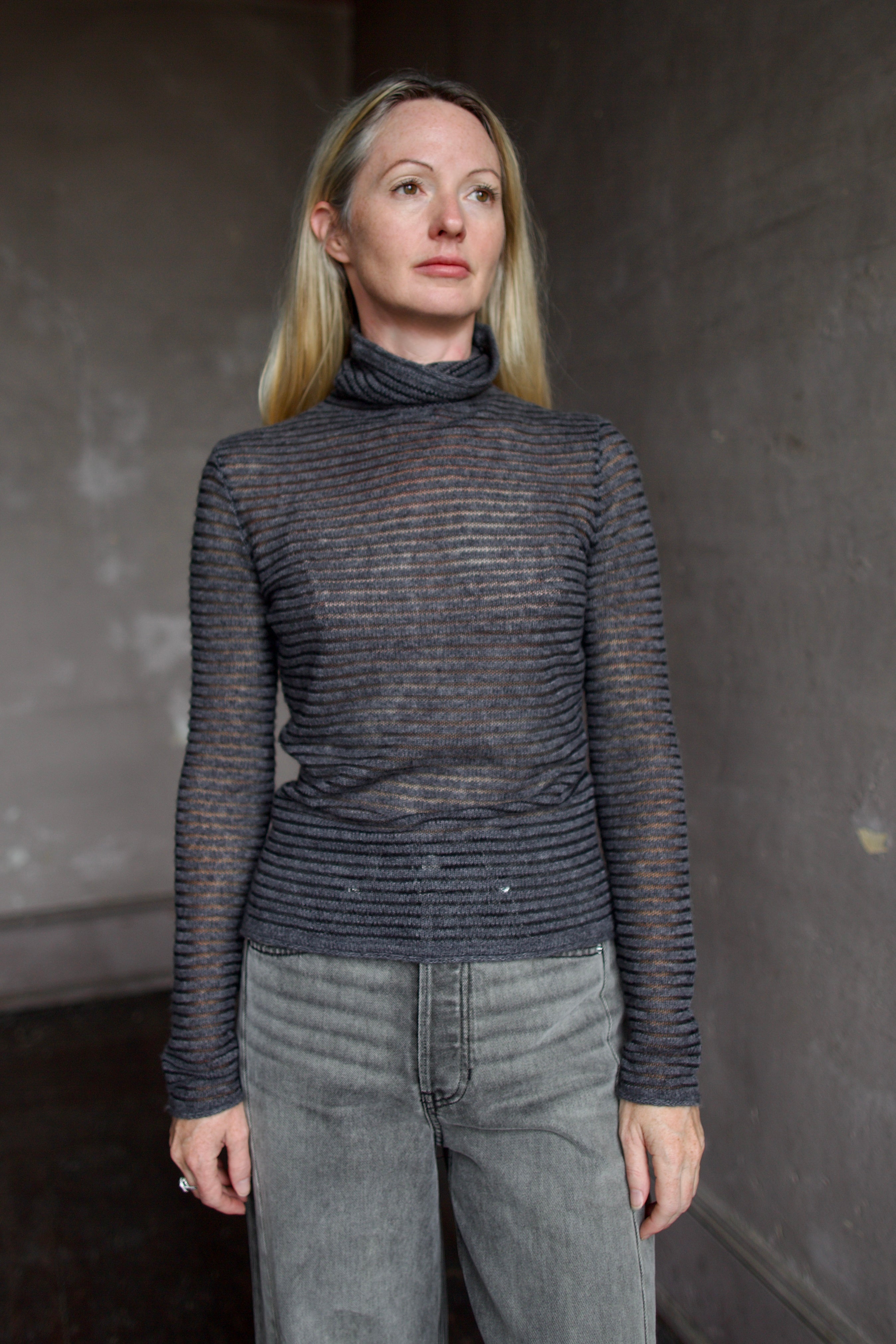Model wearing a dark ribbed Proenza Schouler striped mock neck sweater and gray Veronica Beard barrel denim