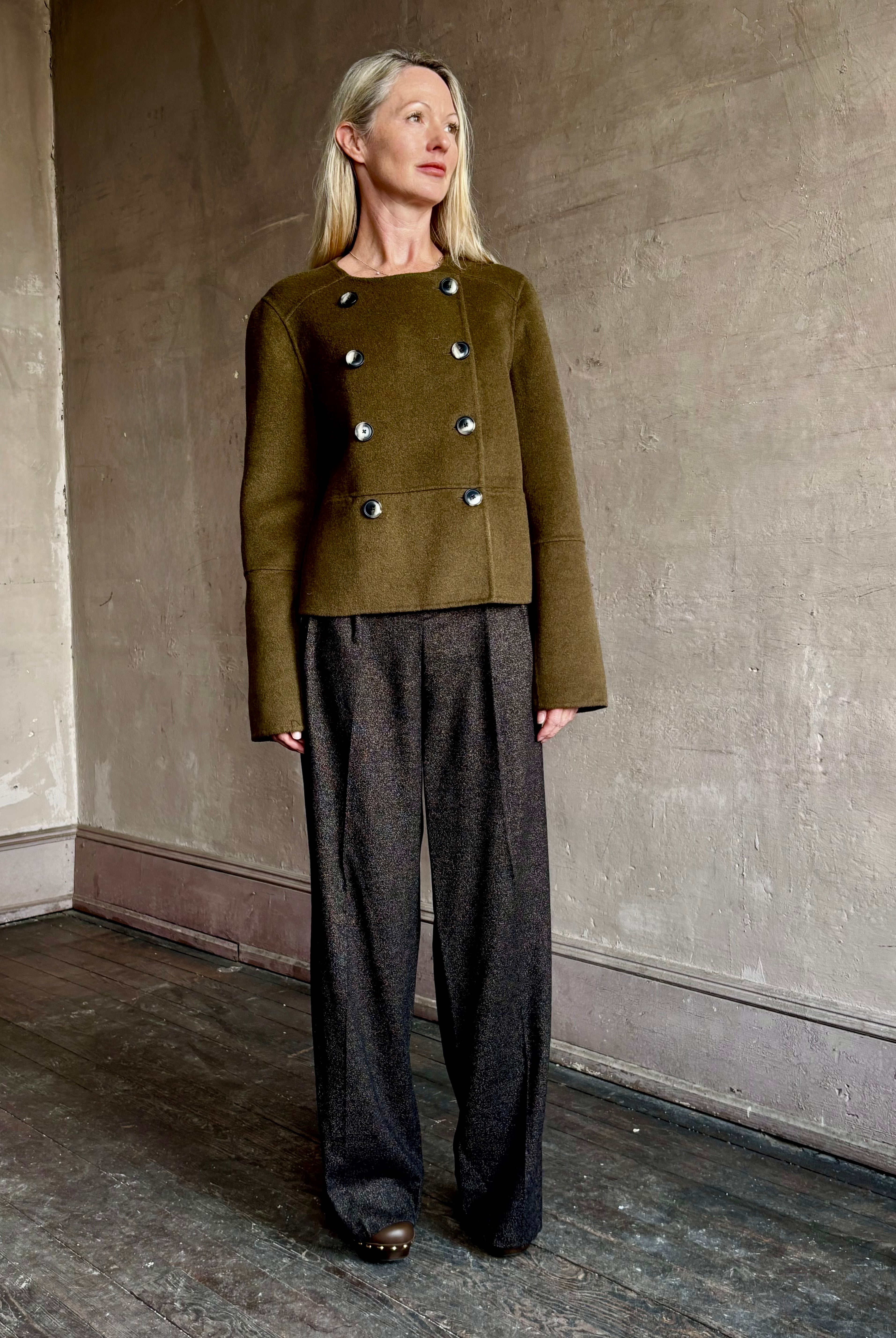 Image of mature woman wearing luxury brand Proenza Schouler cropped army green wool coat with subtle brown buttons
