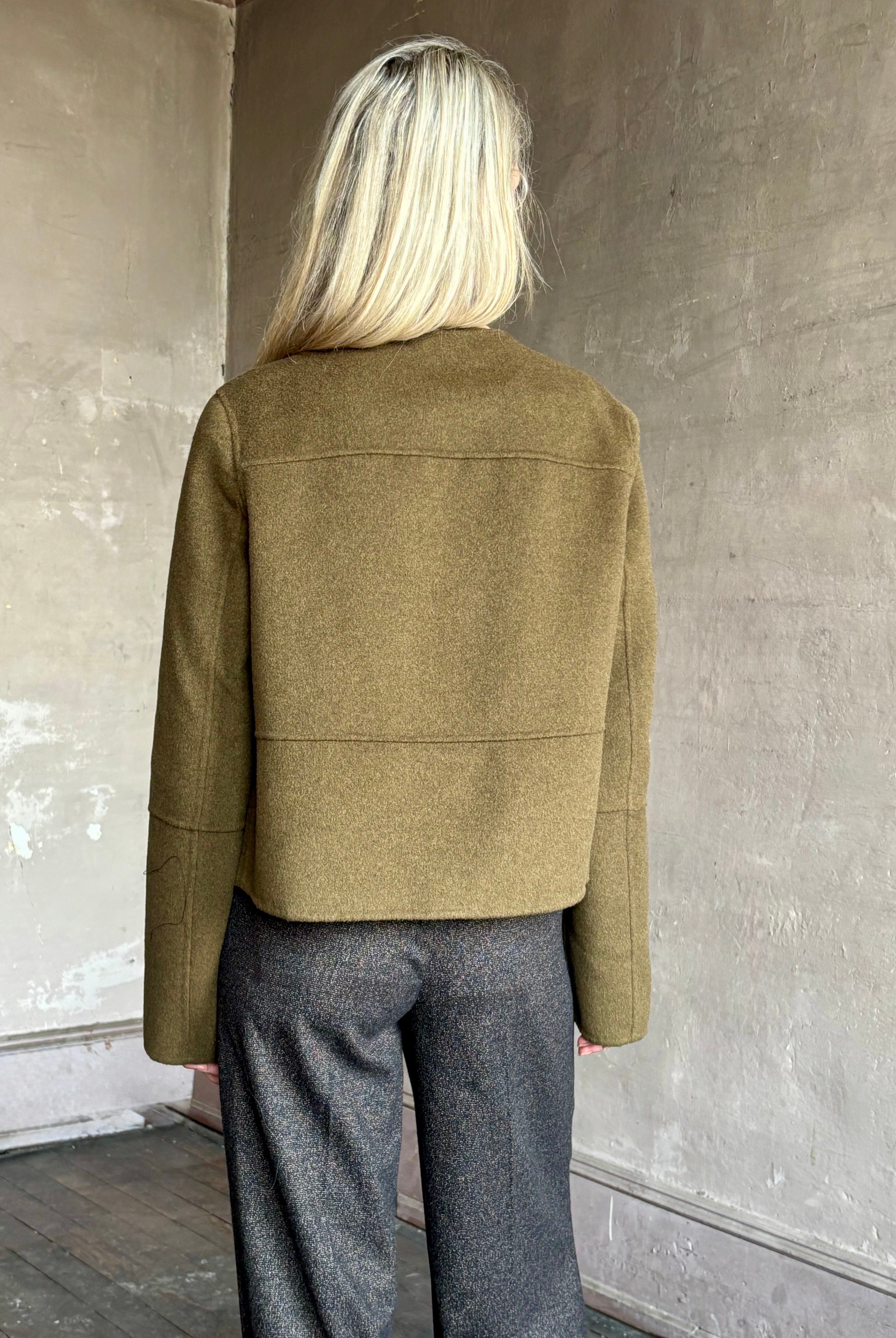 Image of mature woman wearing luxury brand Proenza Schouler cropped army green wool coat with beautiful seam details at back and sleeves