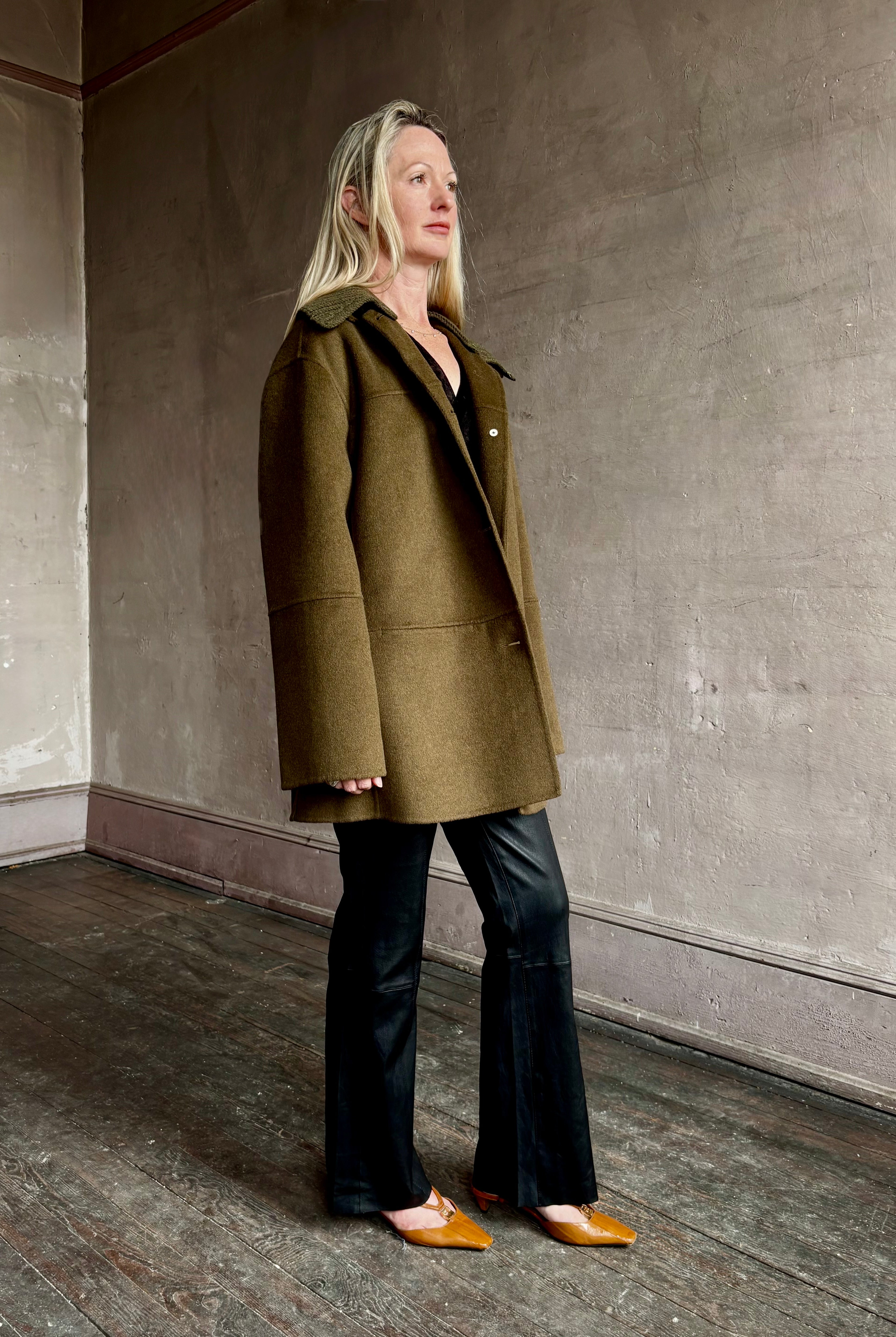 Image of woman wearing luxury brand Proenza Schoulder double faced green wool coat with detachable collar and front pockets