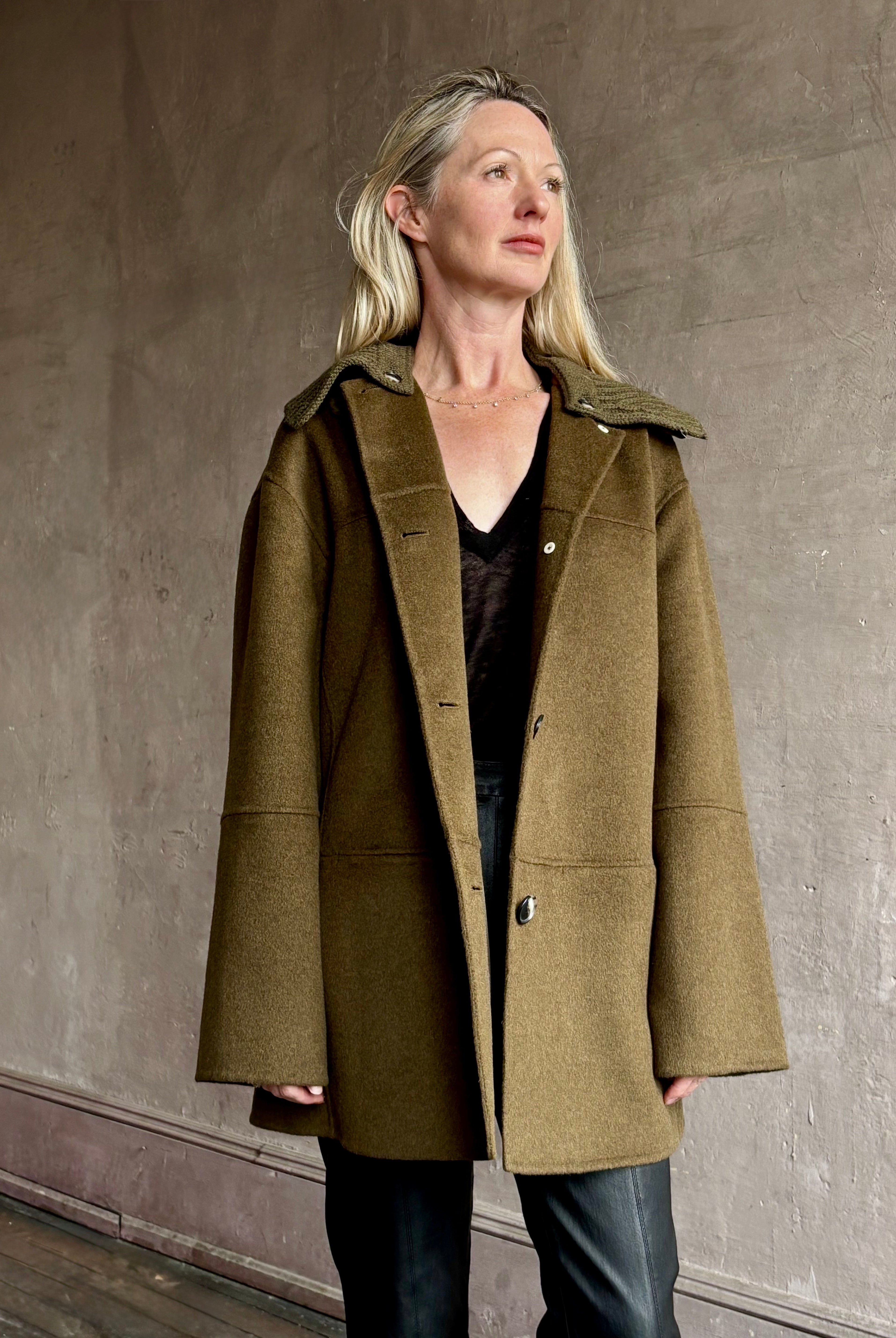 Image of woman wearing luxury brand Proenza Schoulder double faced green wool coat with detachable collar and front pockets