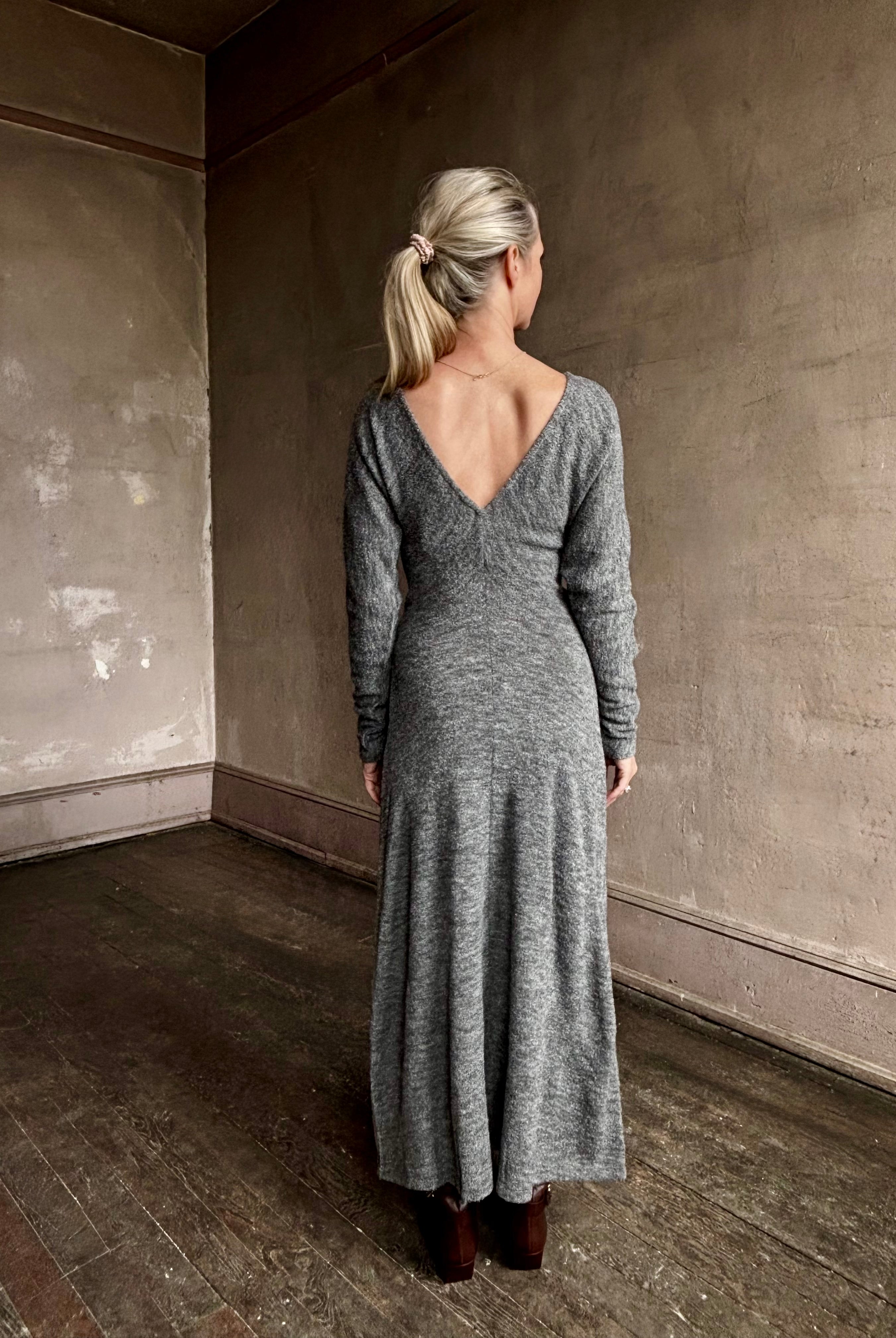 Image of mature woman wearing Proenza Schouler Sai maxi Dress in wool jersey grey with deep V back, long sleeves and draping skirt