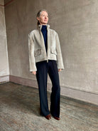Image of a mature woman wearing Proenza Schouler Scarlett shearling jacket with a zip front and pockets for  the ultimate warm luxury coat in a neutral