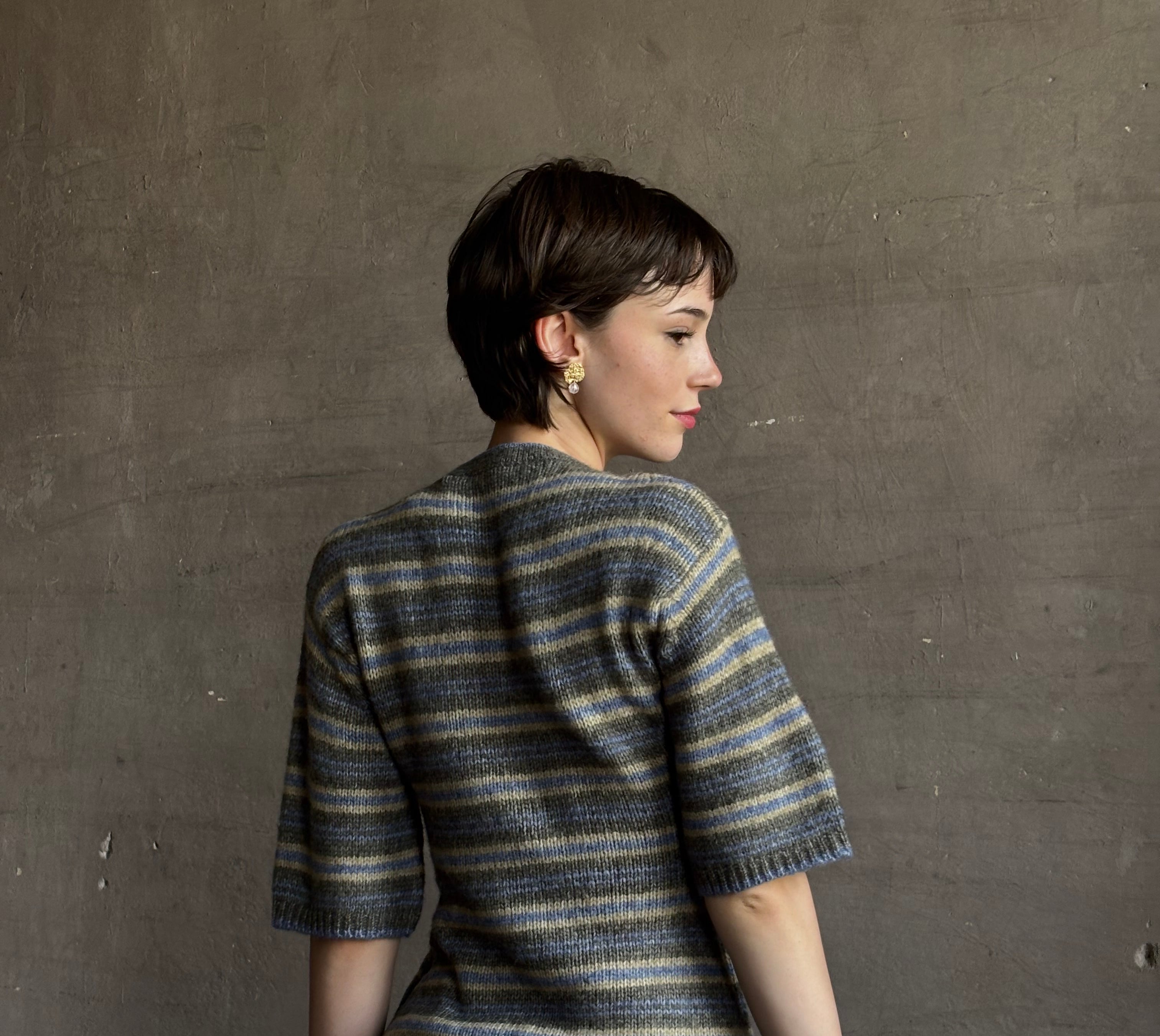 woman wearing Proenza Schoulder Dana sweater with short-sleeve knit top with blue, gray, and beige horizontal stripes