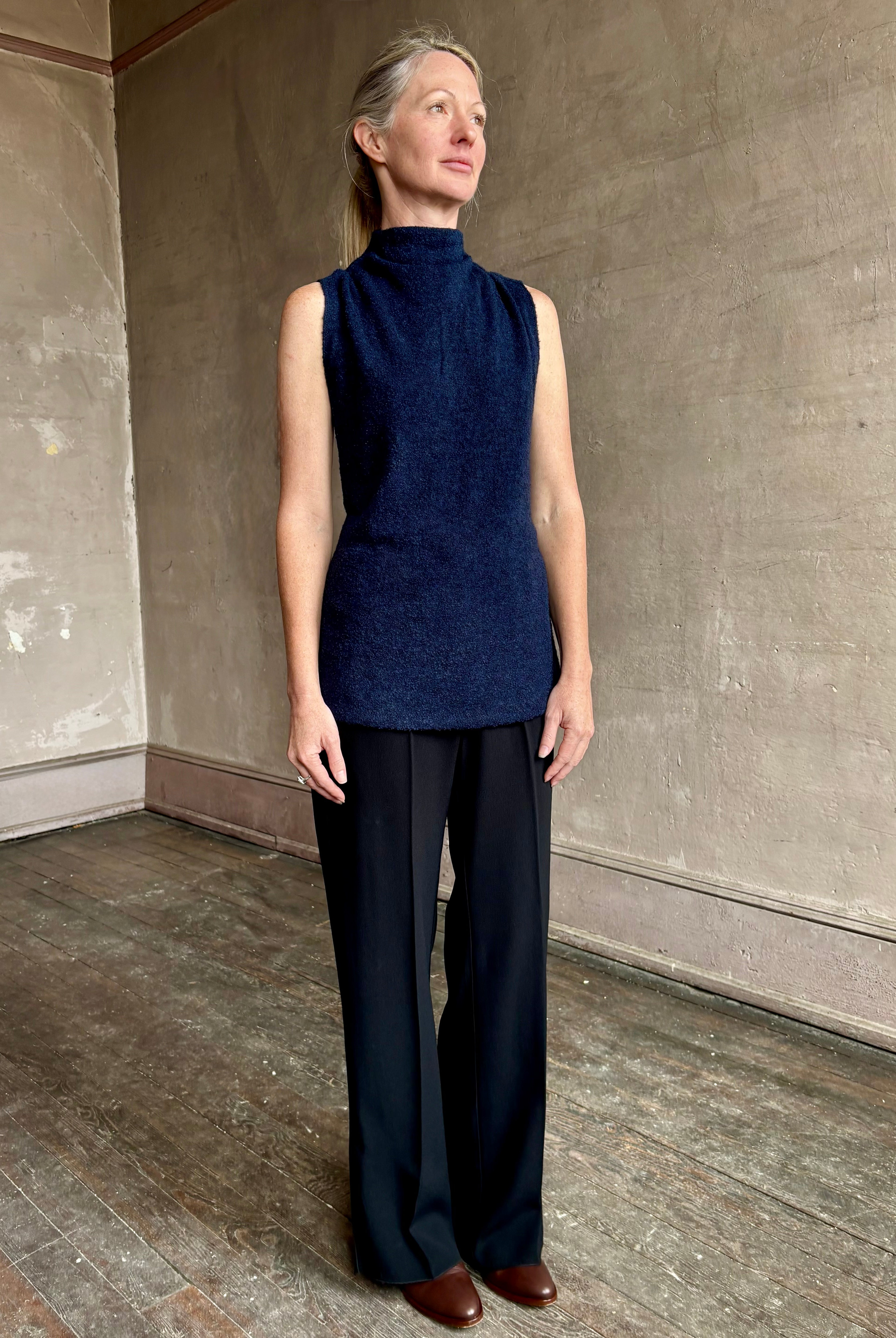 Image of mature woman wearing proenza schouler cynthia sleeveless top in a boucle texture and a mock neck