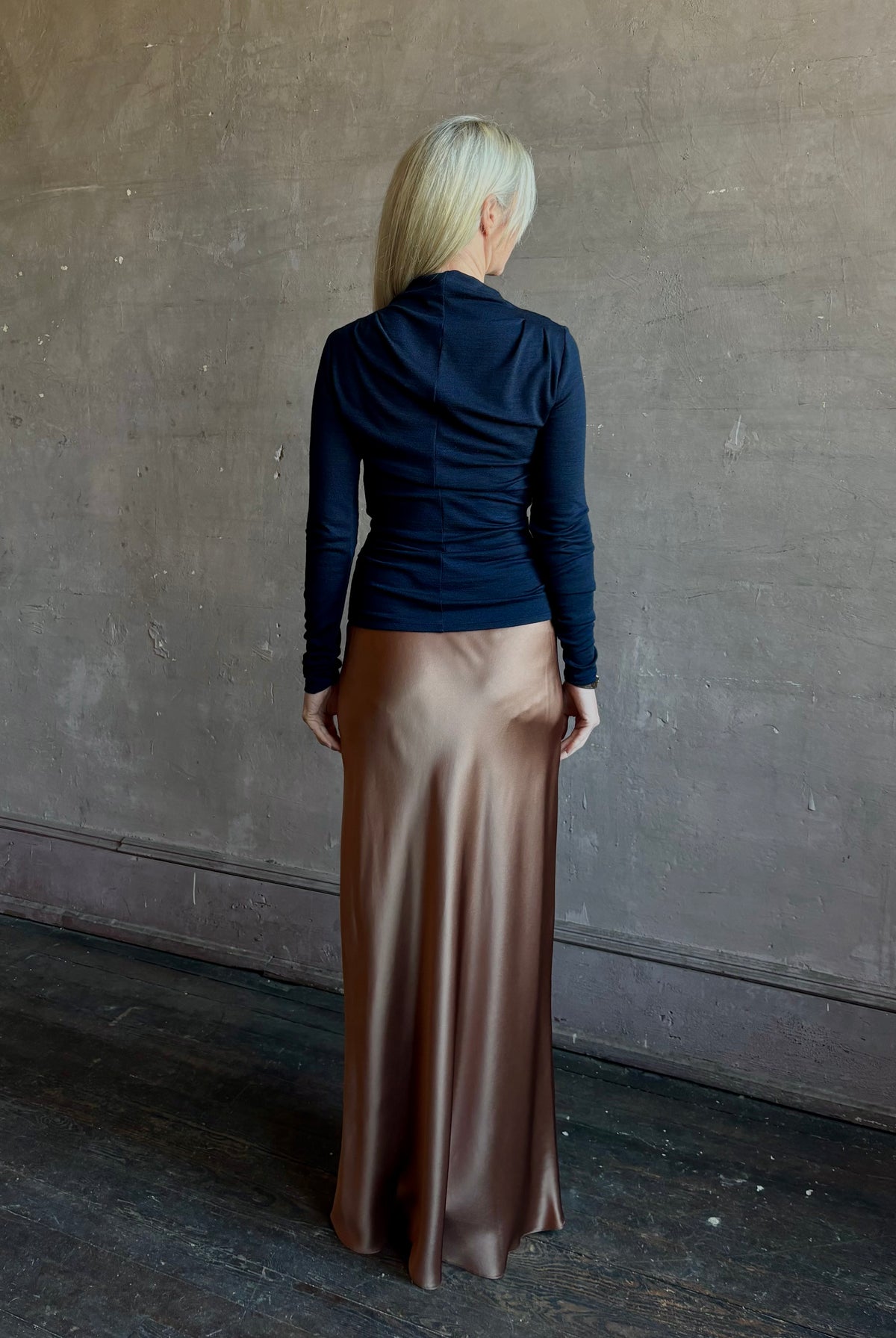 Back image of mature woman wearing Proenza Schouler Mini Jersey Top with shoulder pleats and fluid draping at back with fabric seam down center of back