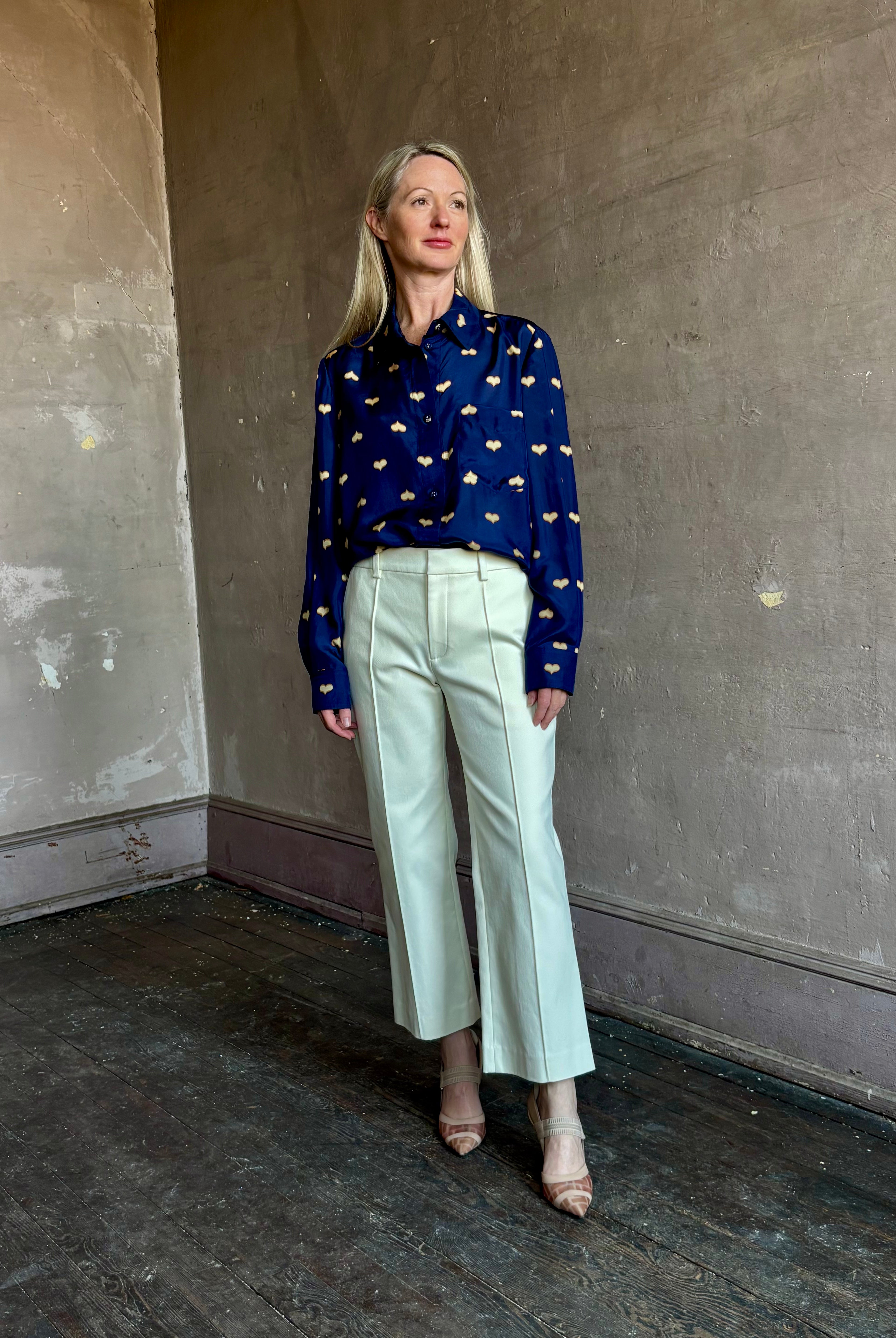 Image of mature woman wearing New York designer Rachel Comey navy silk Lilo button down with long sleeves and heart print with contemporary American style.