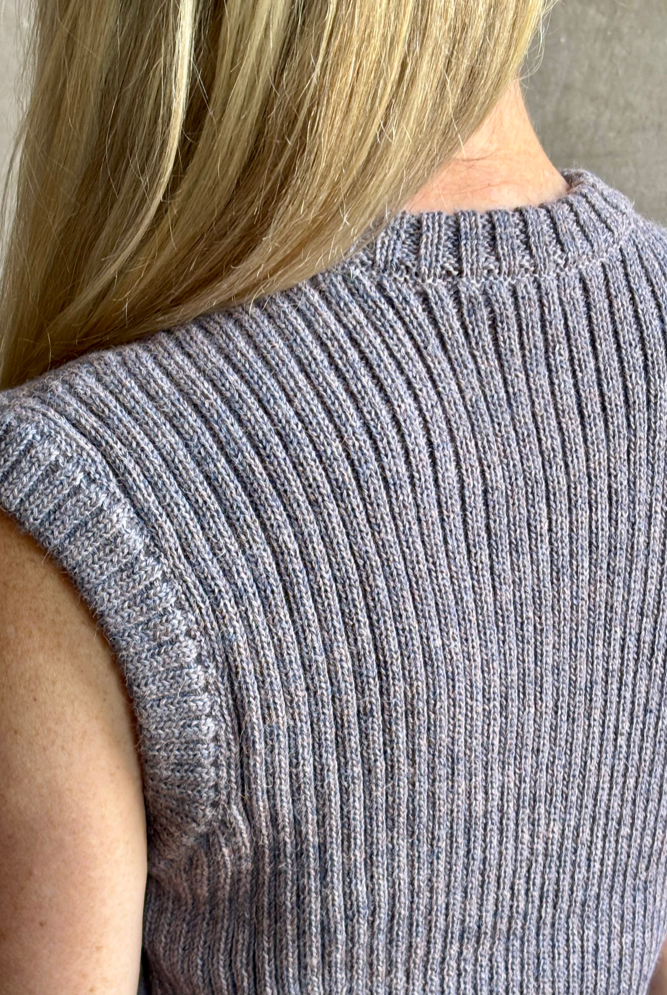 Mature woman wearing a quality lilac knit top fabricated from baby alpaca by designer Rachel Comey