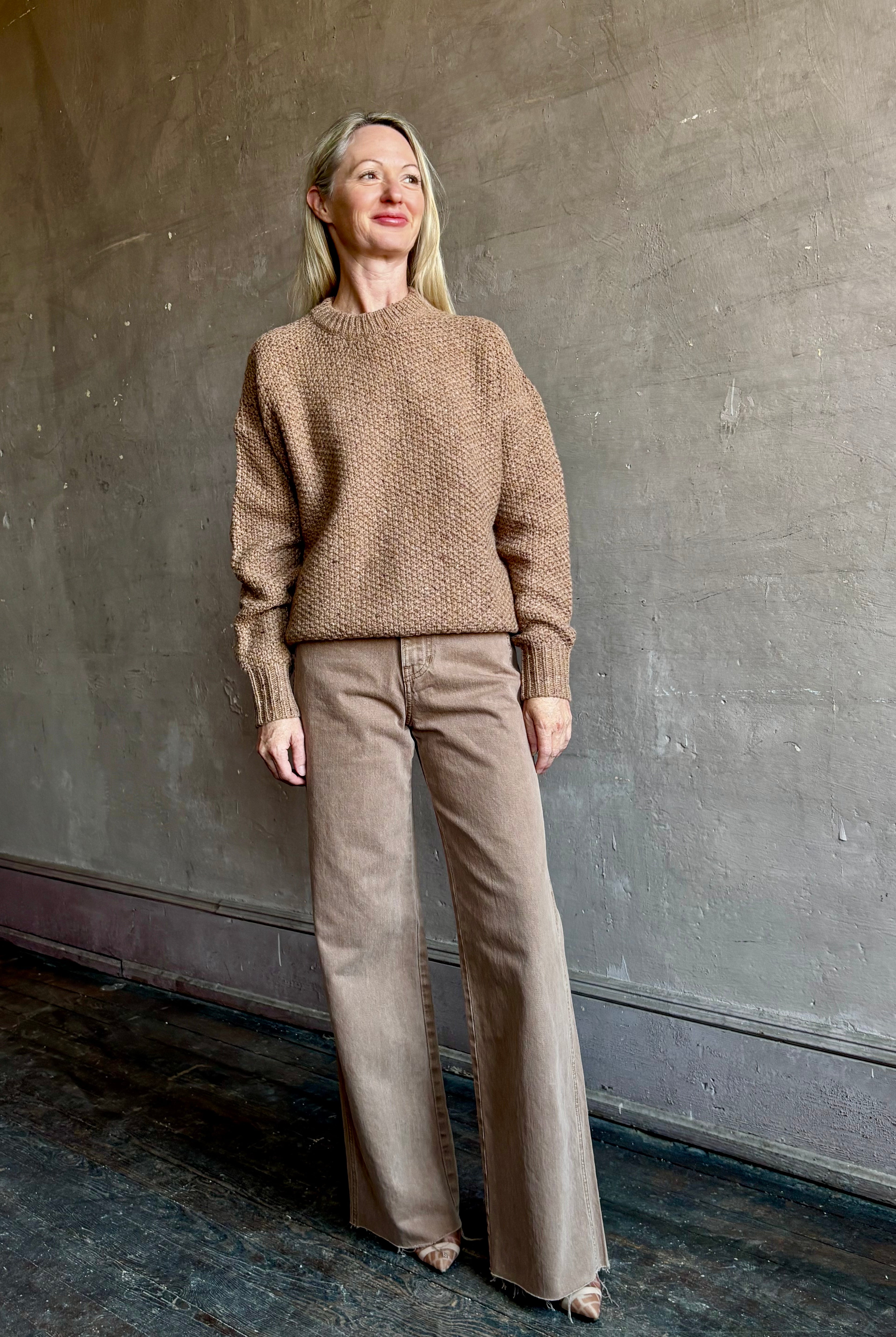 Image of mature woman wearing American designer Rachel Comey prescot sweater in a warm neutral colorway made with fine merino wool