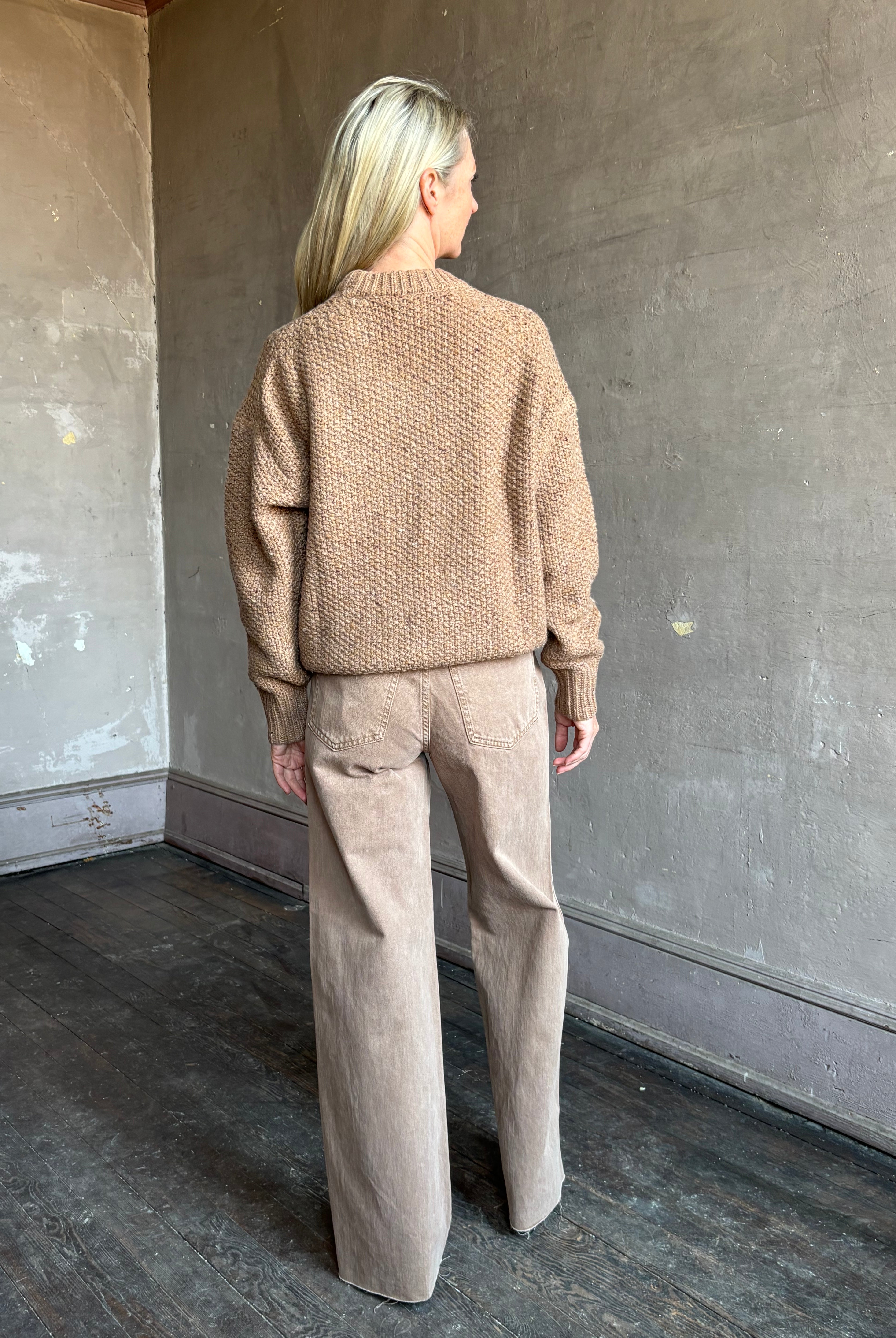 Image of mature woman wearing American designer Rachel Comey prescot sweater in a warm neutral colorway made with fine merino wool