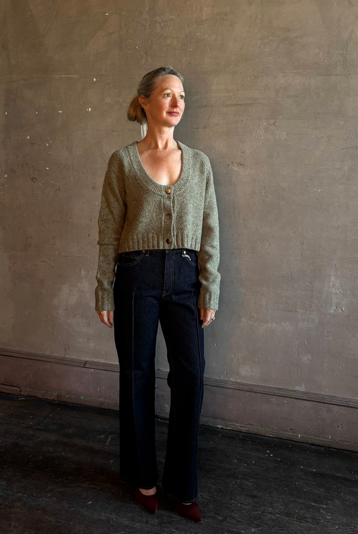 Mature woman wearing Rachel Comey Uridge Cardigan in Stone Green RWS-certified merino blend with U-neckline everyday layering