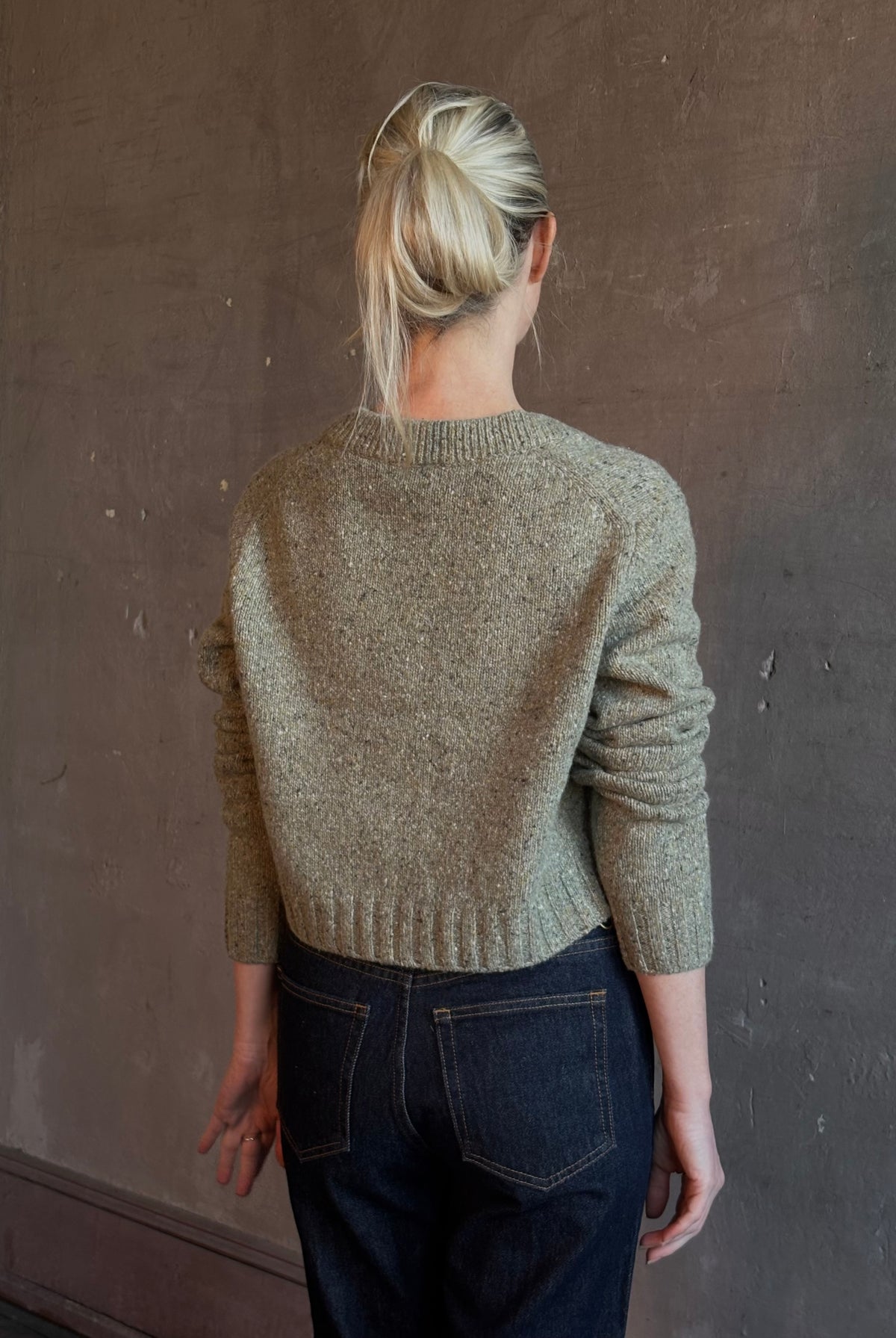 Mature woman wearing Rachel Comey Uridge Cardigan in Stone Green RWS-certified merino blend with U-neckline everyday layering